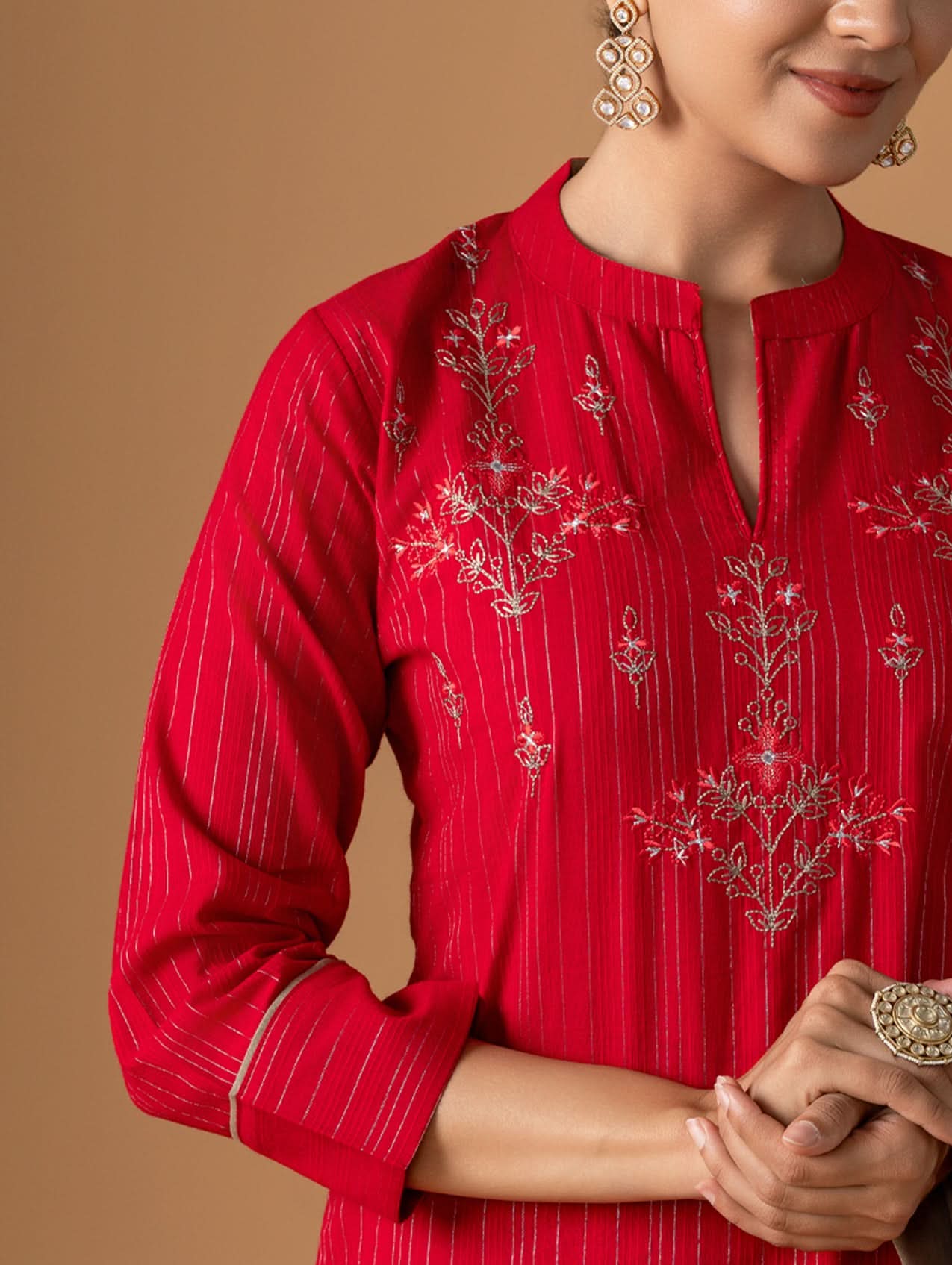 Red embroidered blouse with intricate patterns on a brown background
