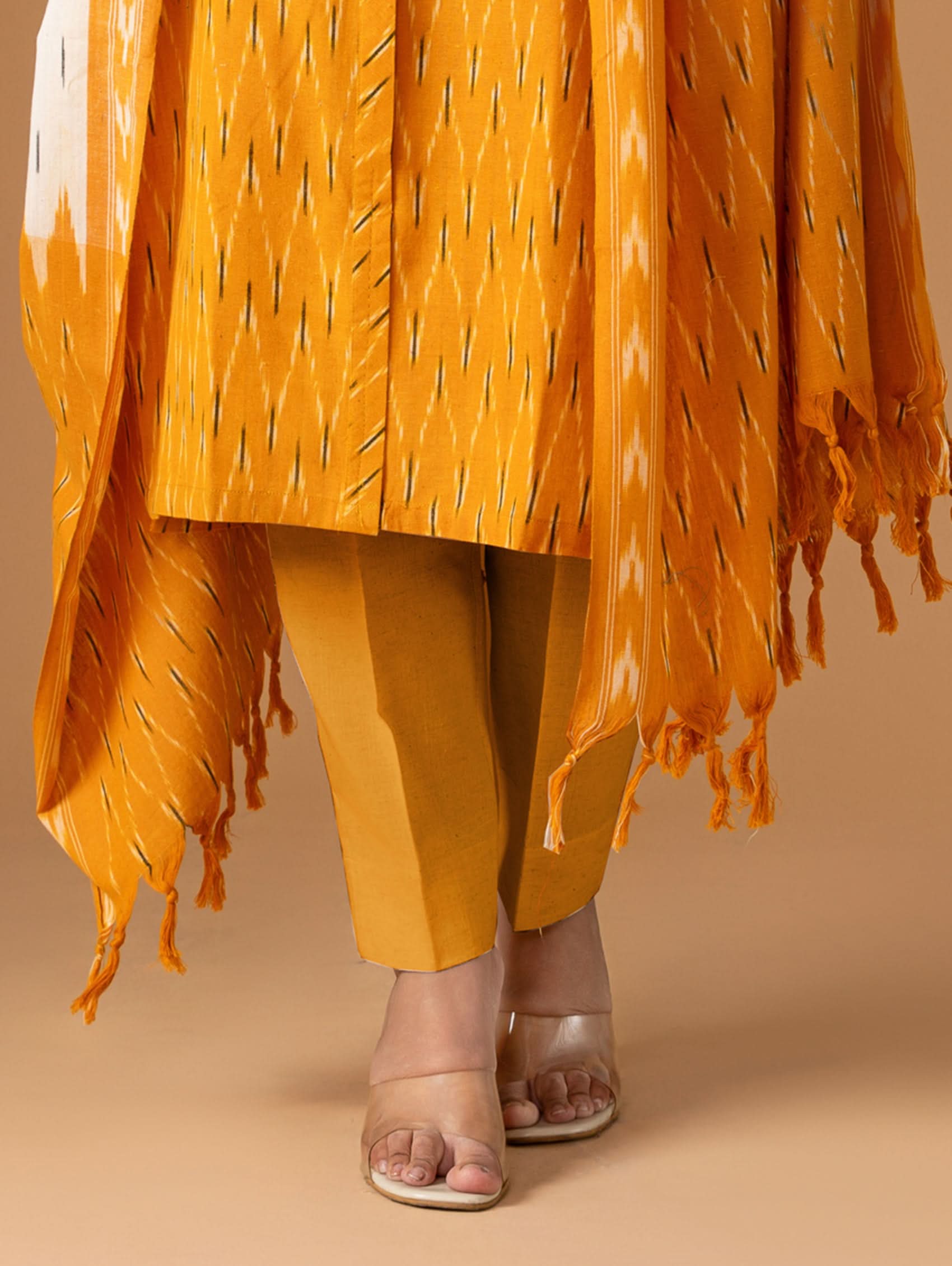 Orange traditional outfit with a matching shawl on a beige background