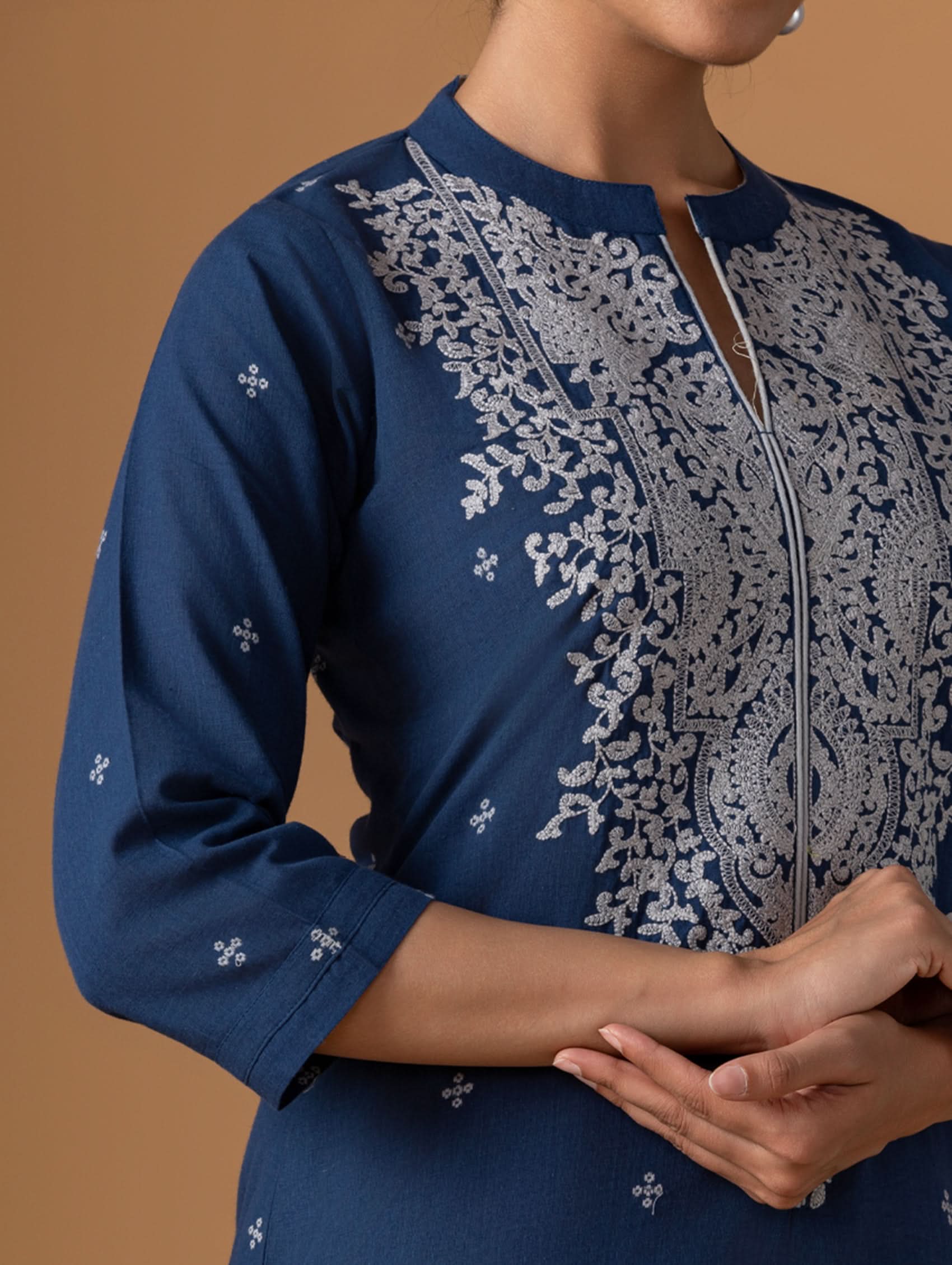 Navy blue kurta with intricate white embroidery on a brown background