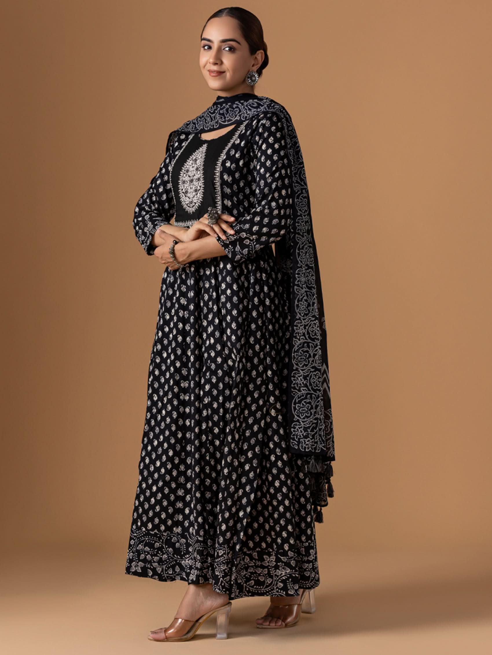 Woman wearing a black and white patterned outfit on a brown background