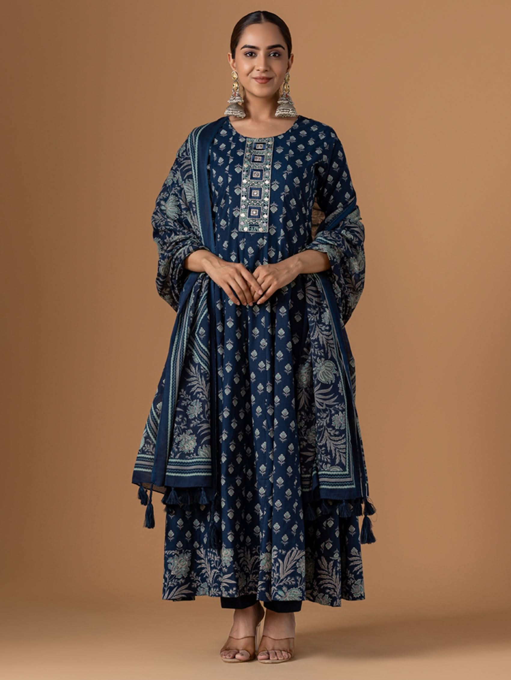 Woman wearing a blue patterned outfit on a brown background