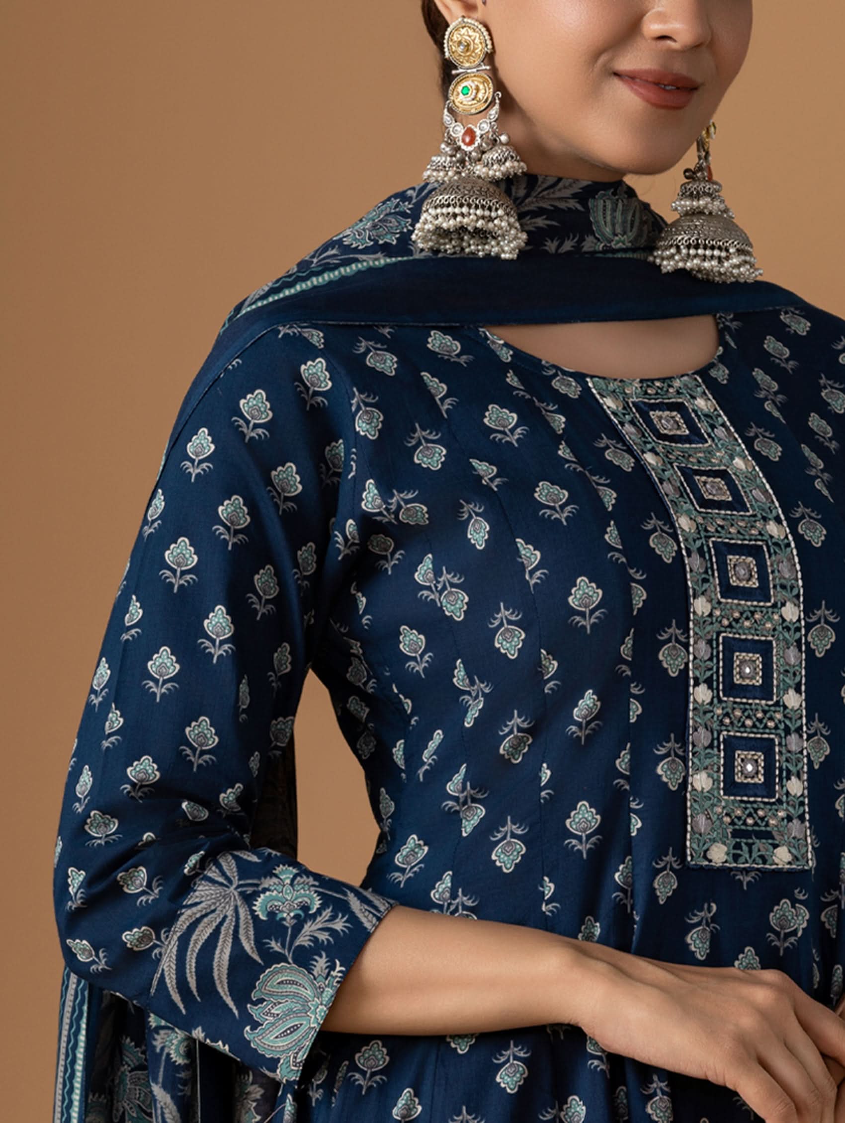 Navy blue embroidered traditional outfit with silver details on a beige background