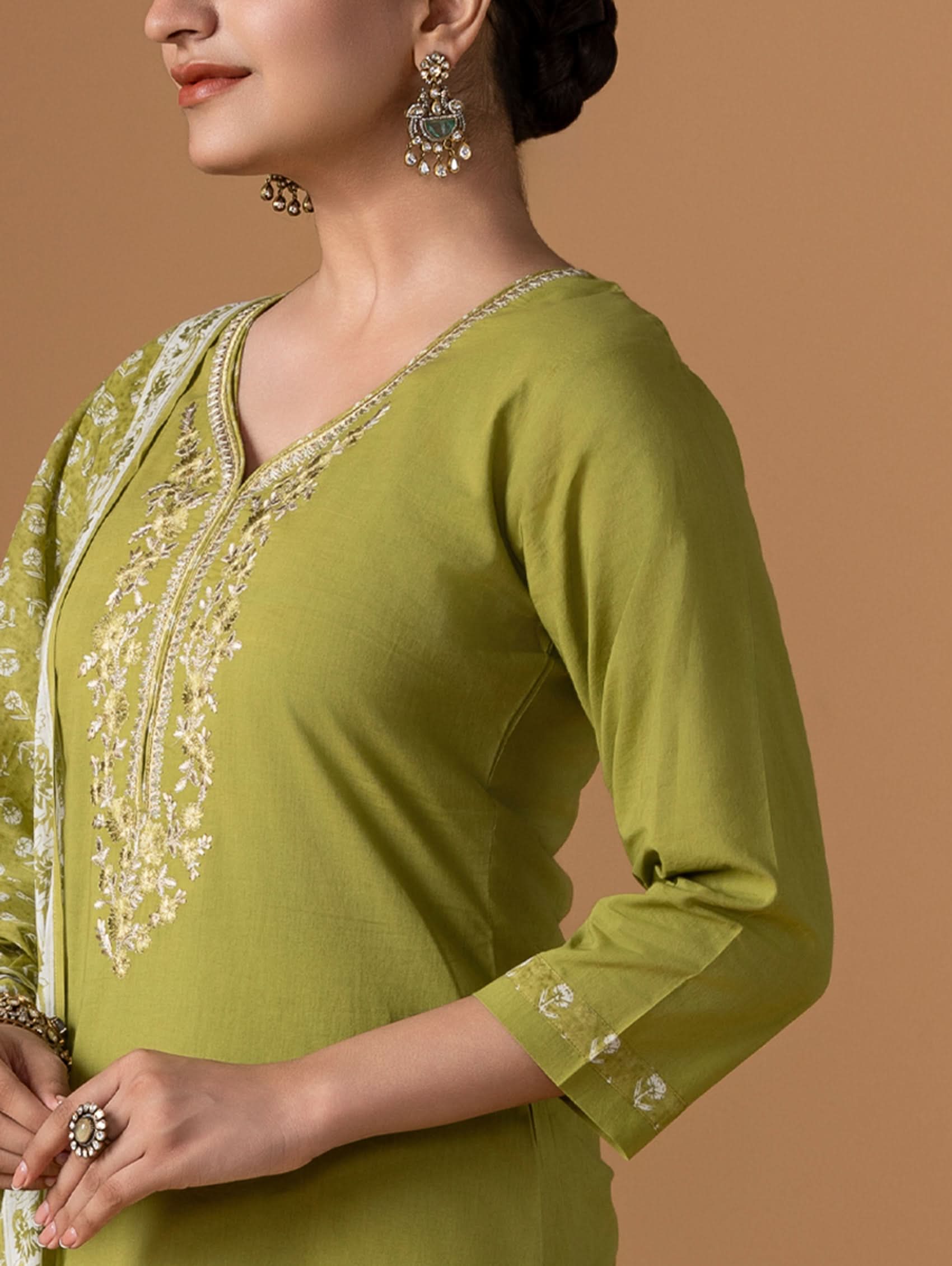 Green embroidered traditional outfit on a brown background