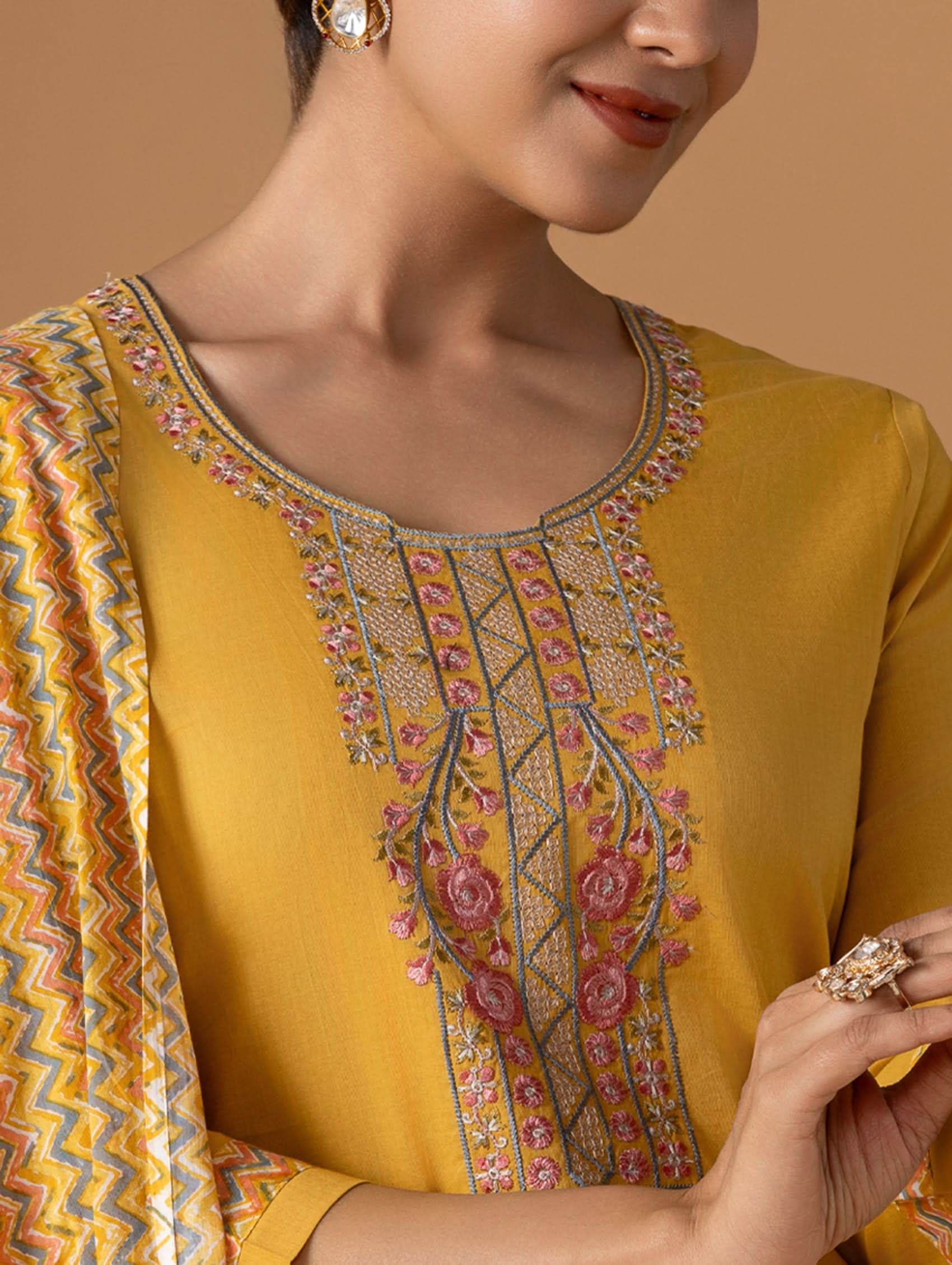 Yellow embroidered blouse with a patterned border on a brown background