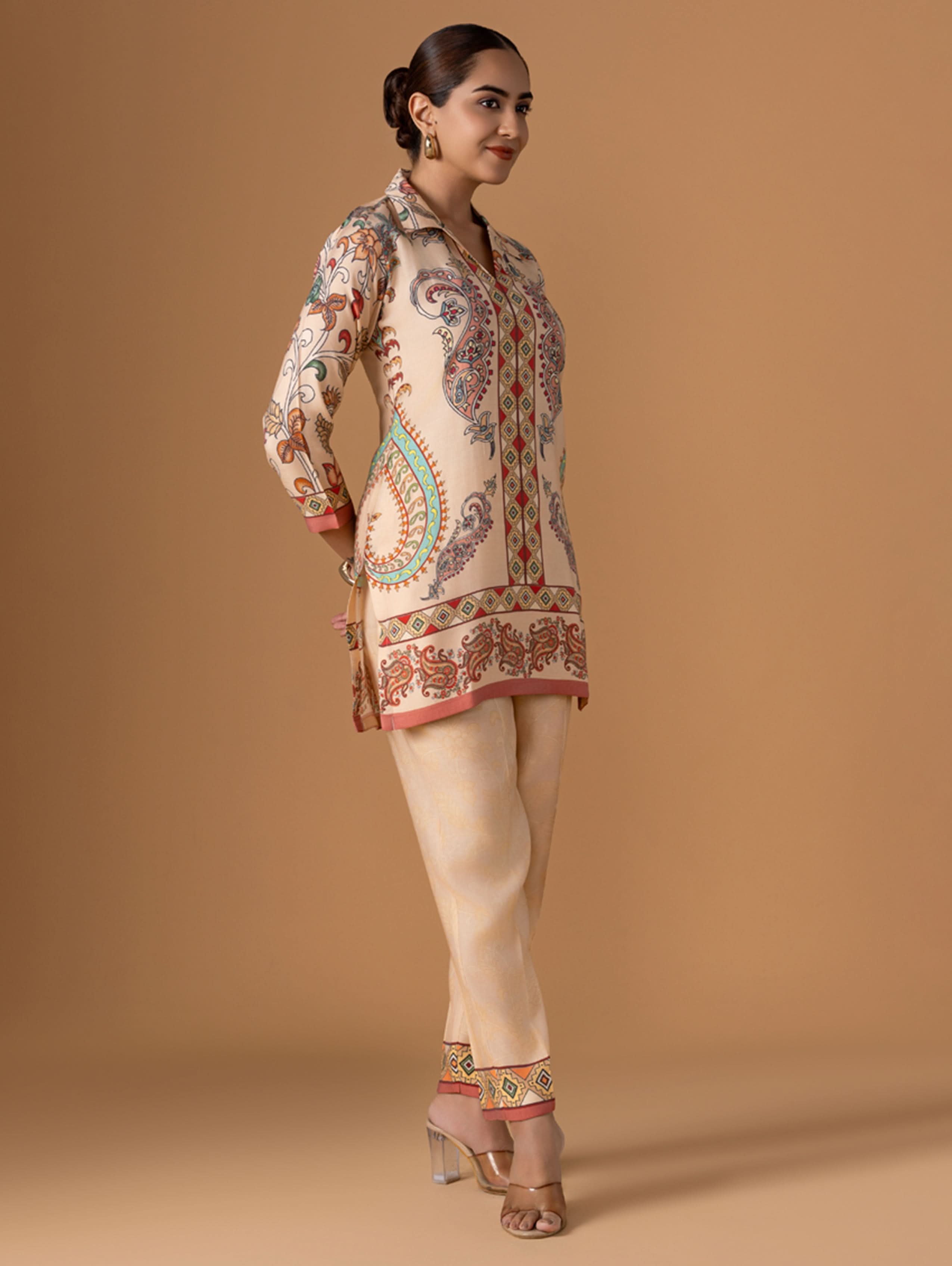 Woman wearing a patterned outfit on a beige background