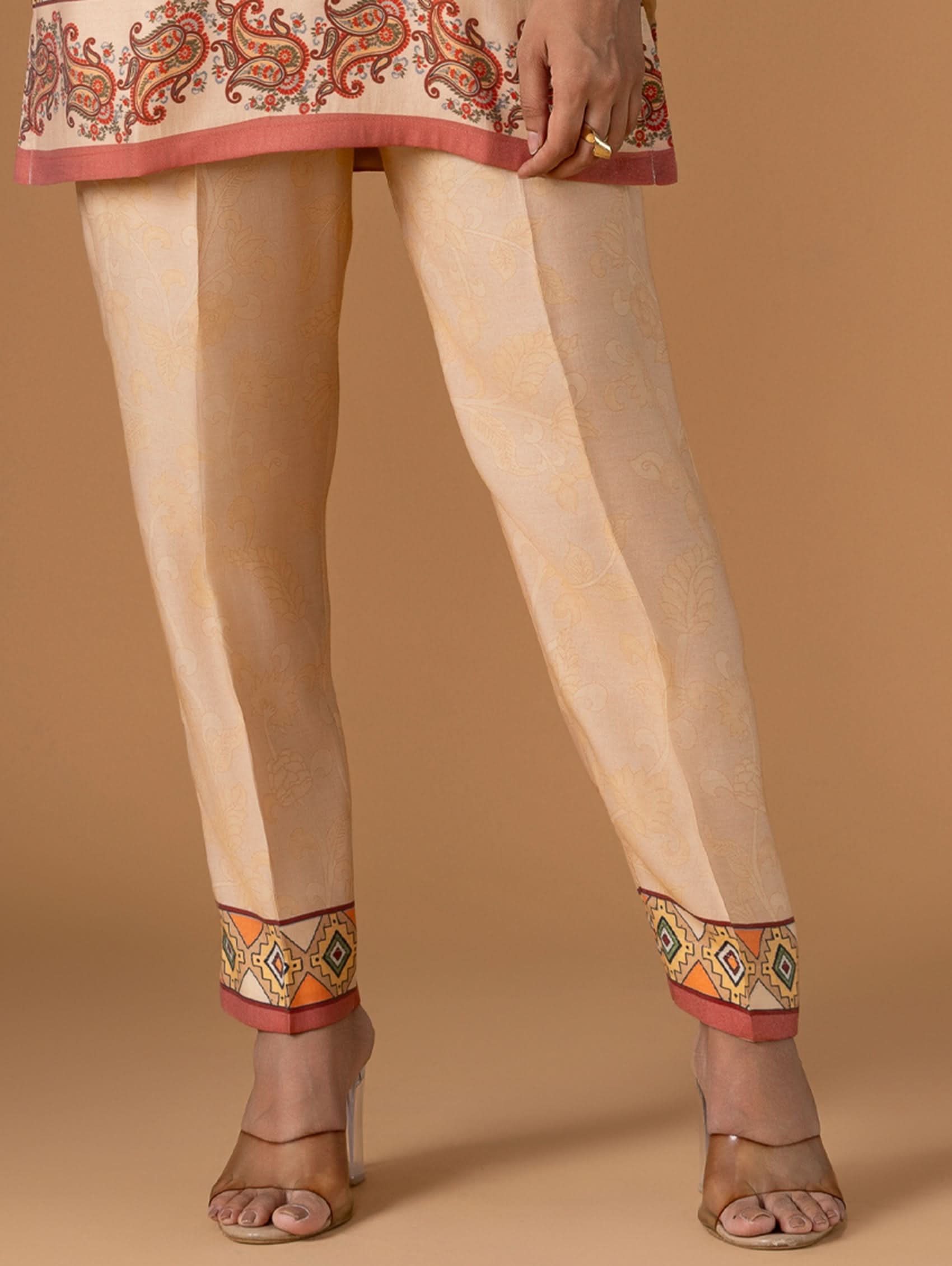 Beige pants with colorful embroidery on a beige background