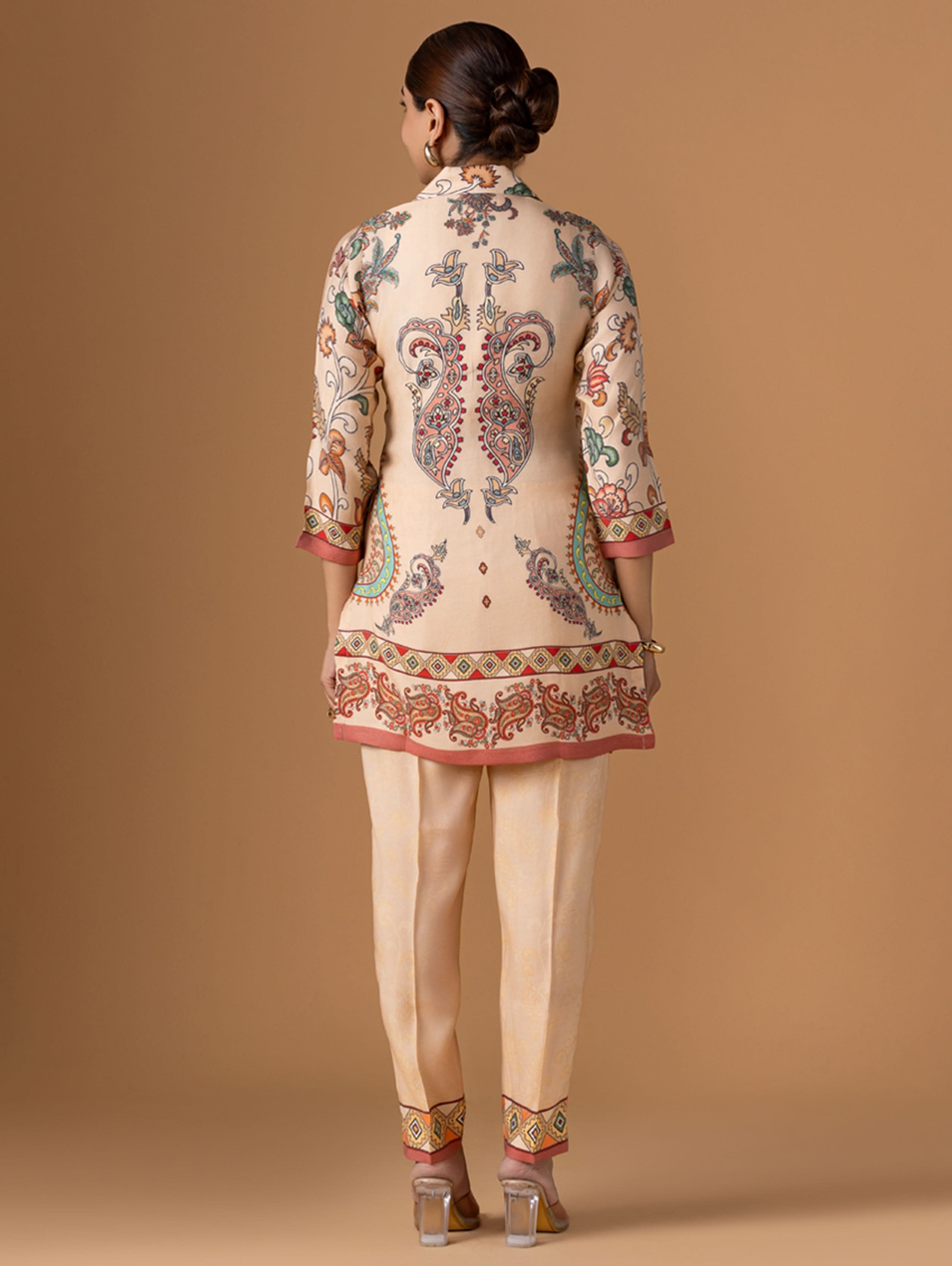 Woman wearing a traditional embroidered outfit on a beige background