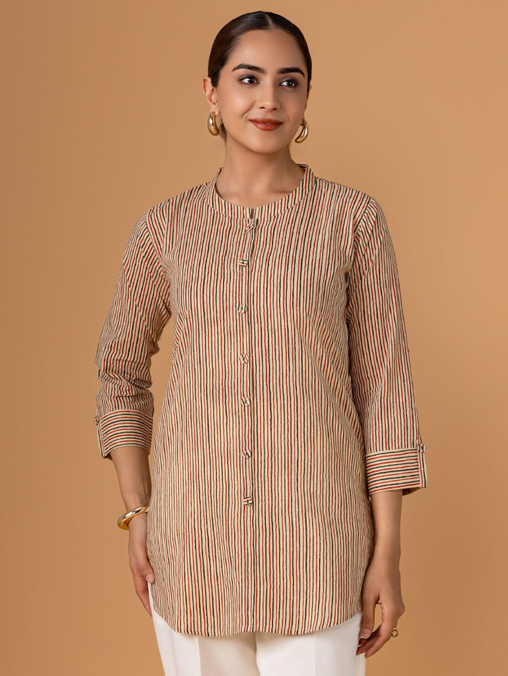 Woman wearing a striped kurta against a brown background