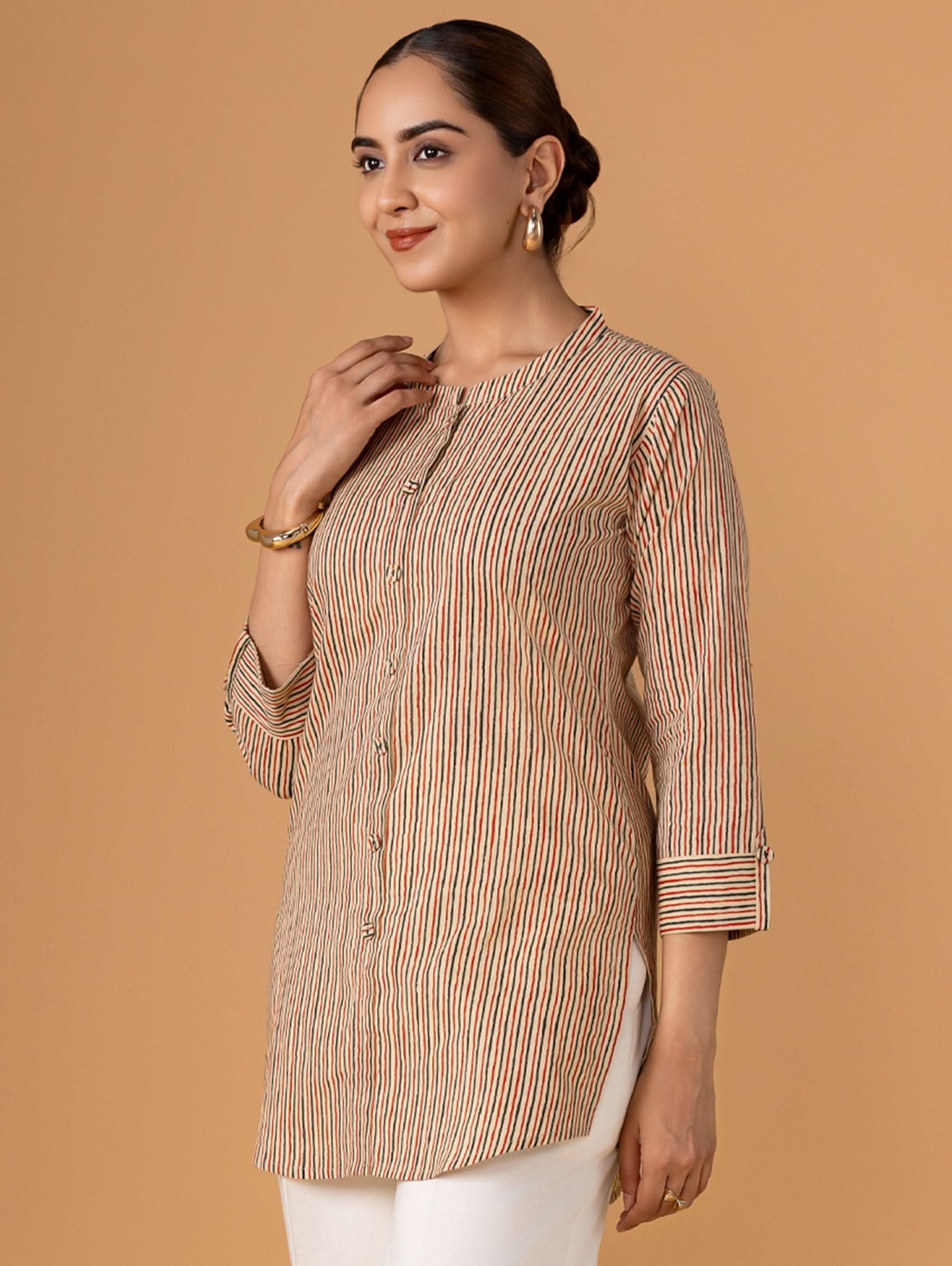 Woman wearing a striped kurta against a beige background