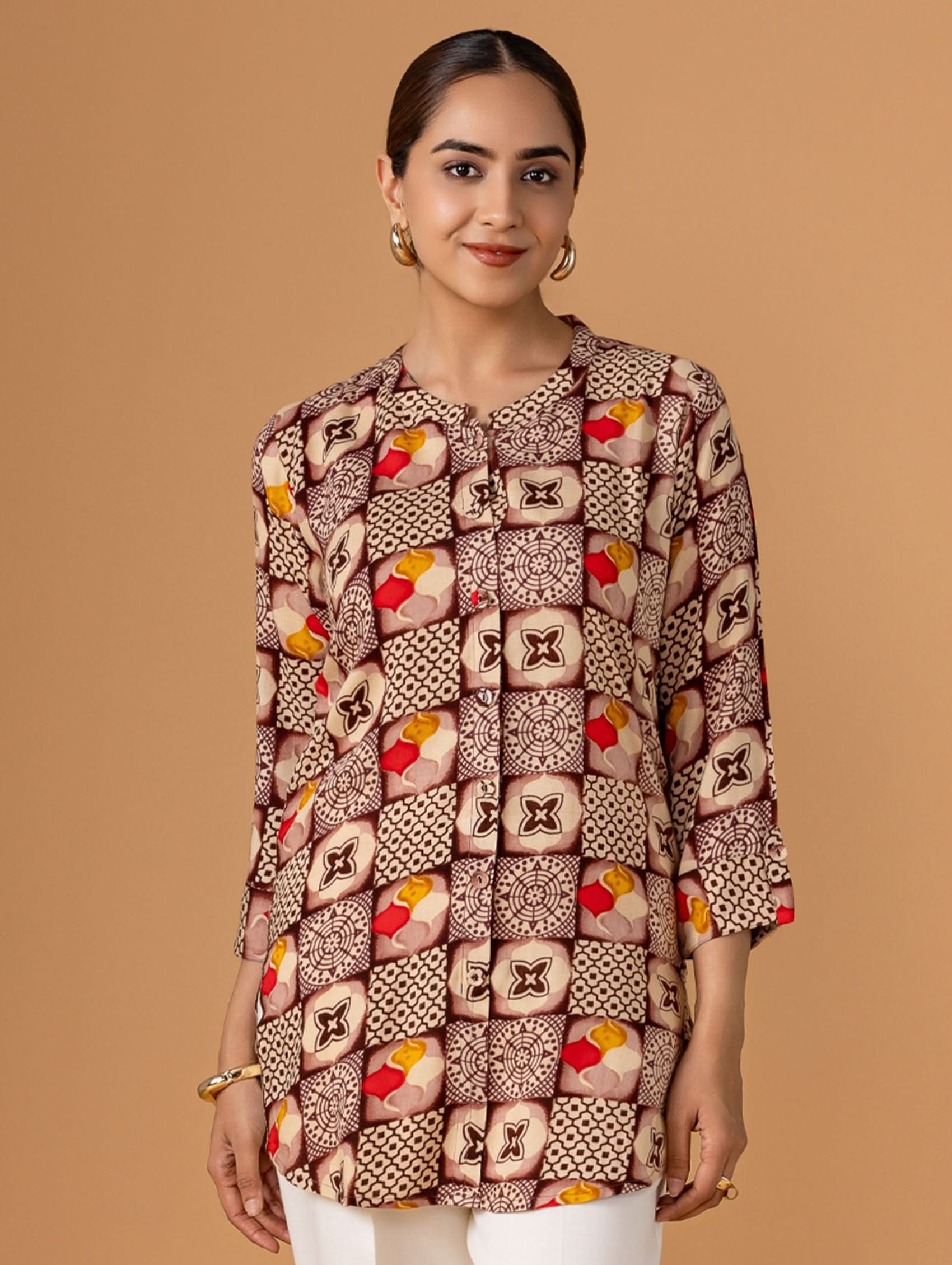 Woman wearing a patterned blouse against a brown background