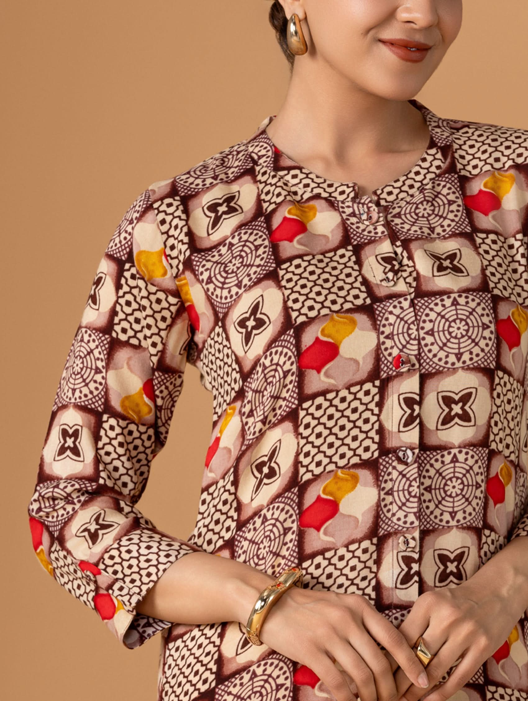 Person wearing a patterned outfit with a beige background