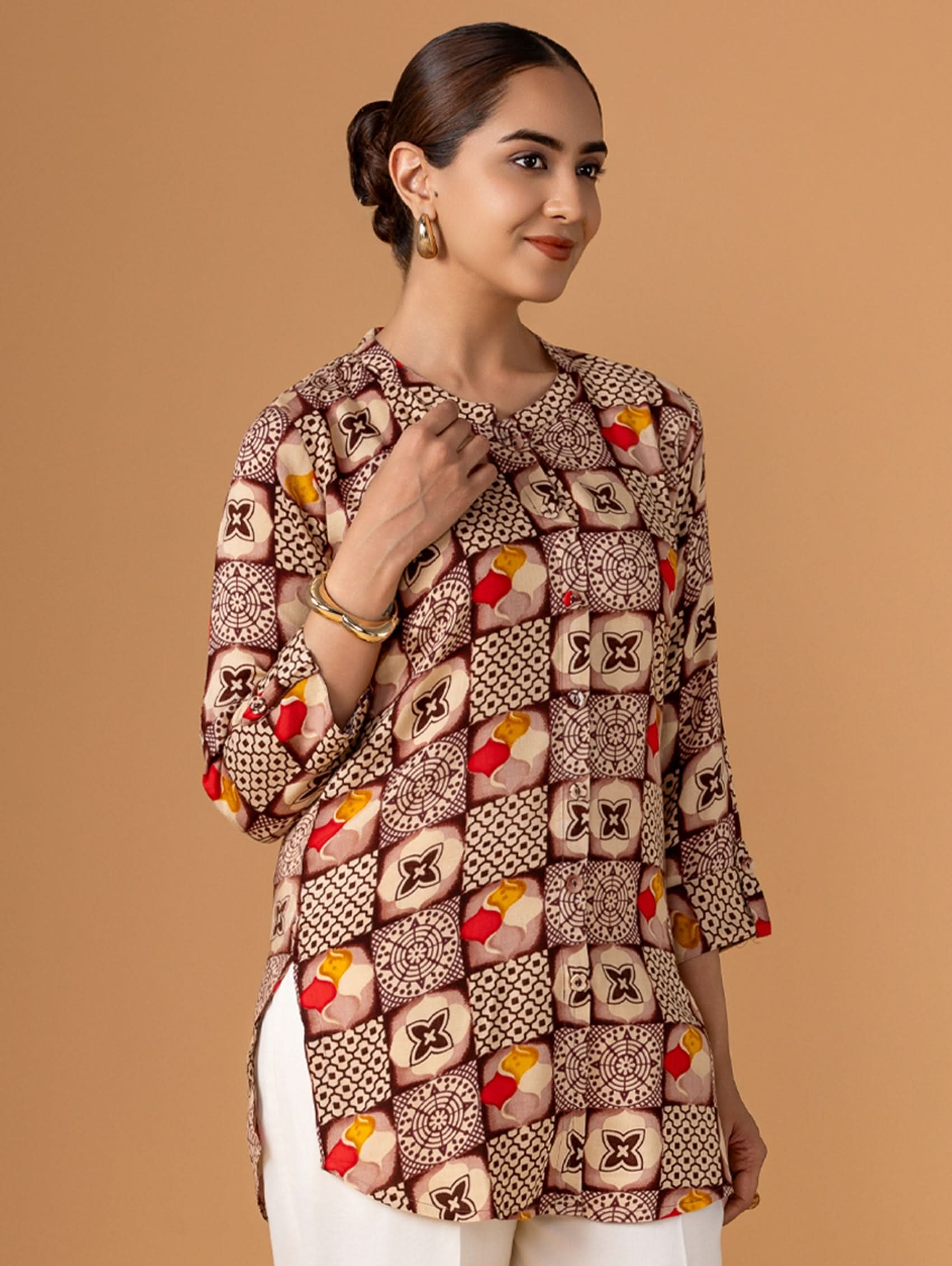 Woman wearing a patterned jacket against a beige background