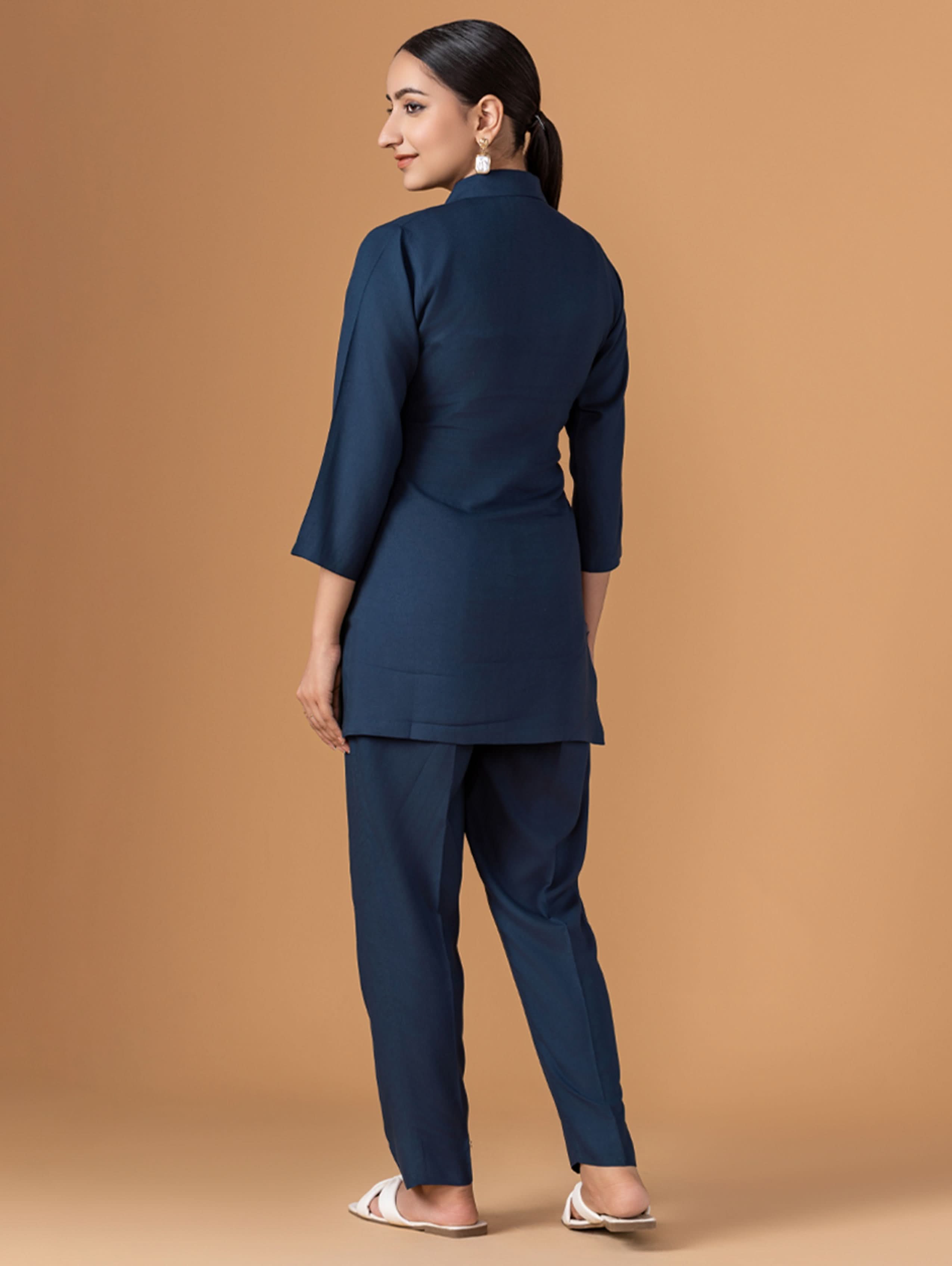 Woman wearing a navy blue outfit on a beige background