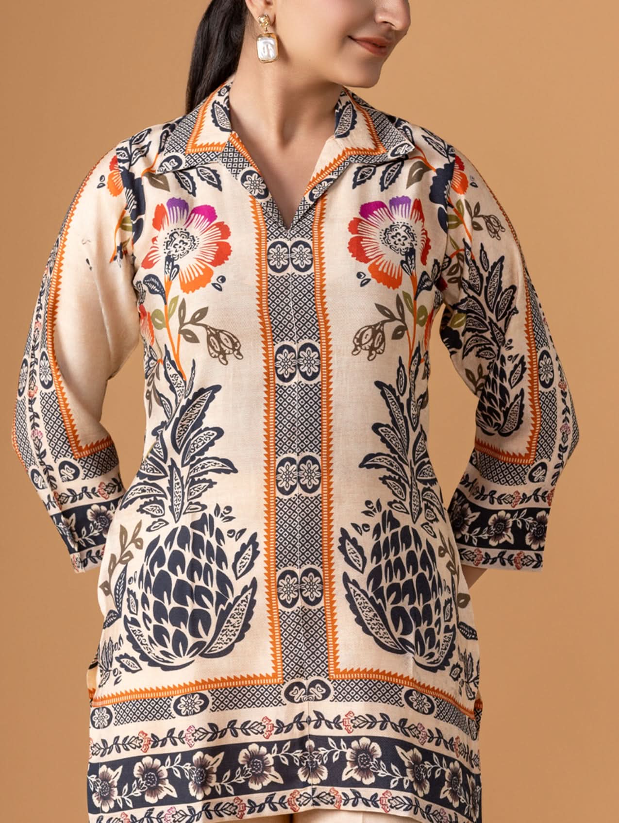 Woman wearing a patterned kurta against a beige background
