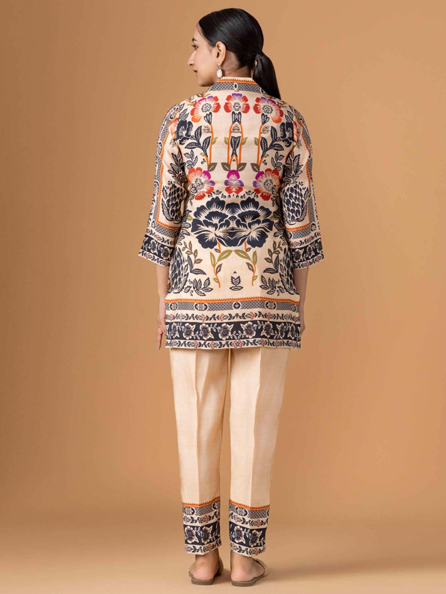 Woman wearing a patterned outfit on a beige background