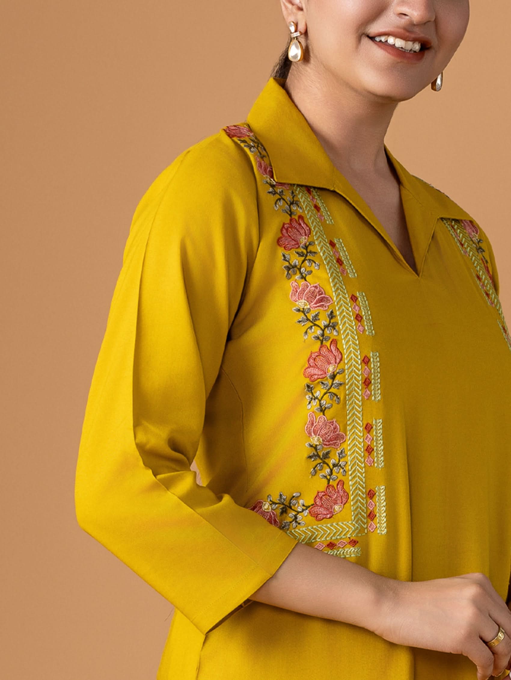 Yellow kurta with floral embroidery on a brown background