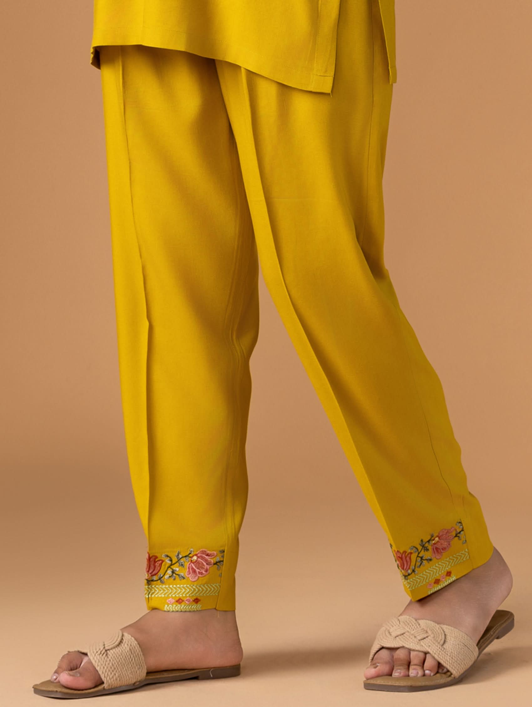 Yellow embroidered pants on a beige background