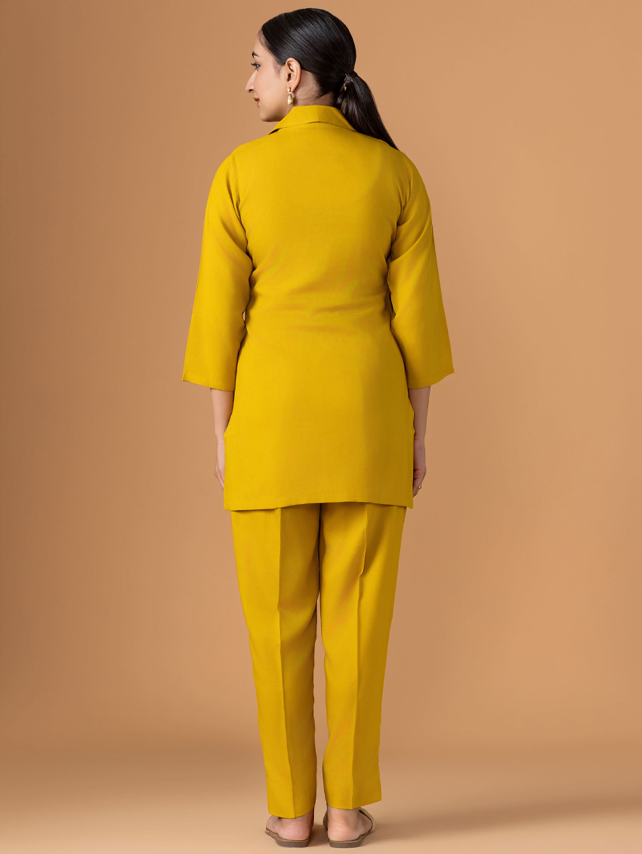 Woman wearing a mustard yellow outfit against a beige background