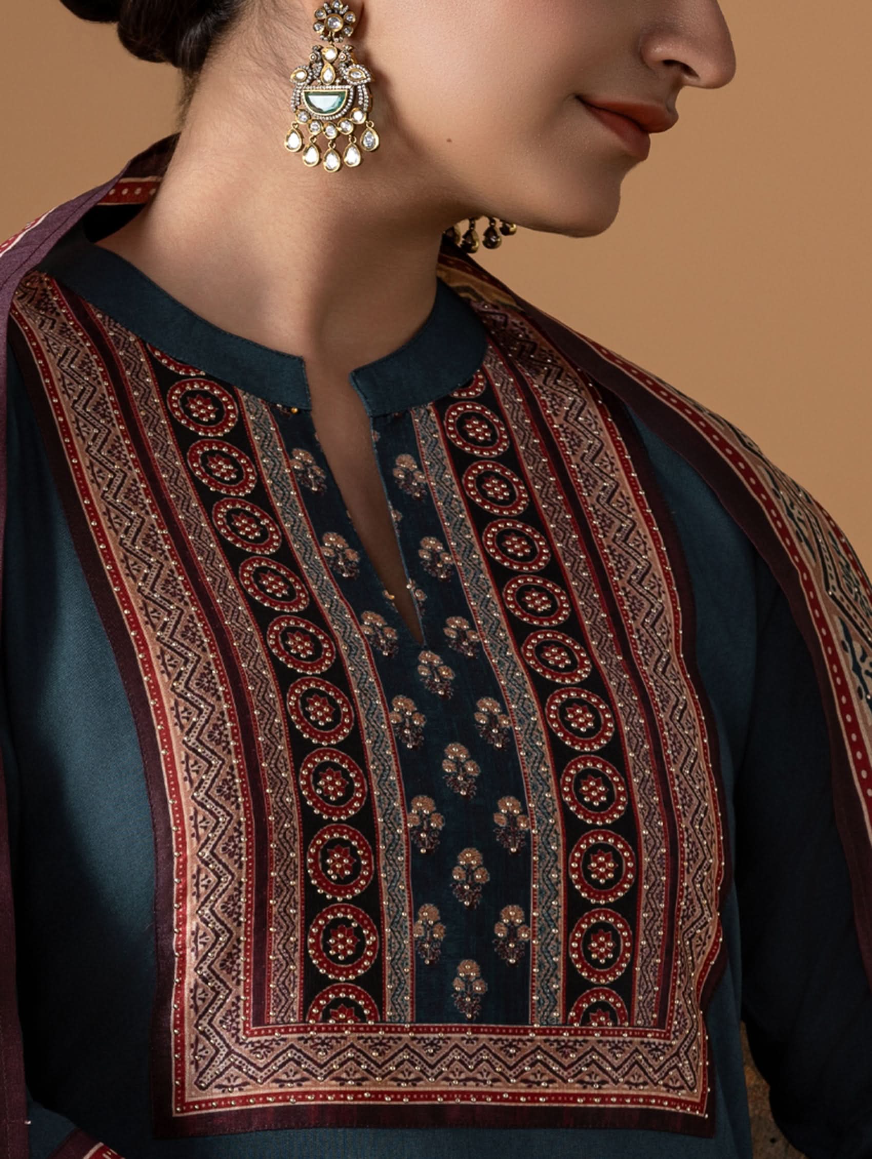 Close-up of a person wearing a traditional embroidered garment with intricate patterns.