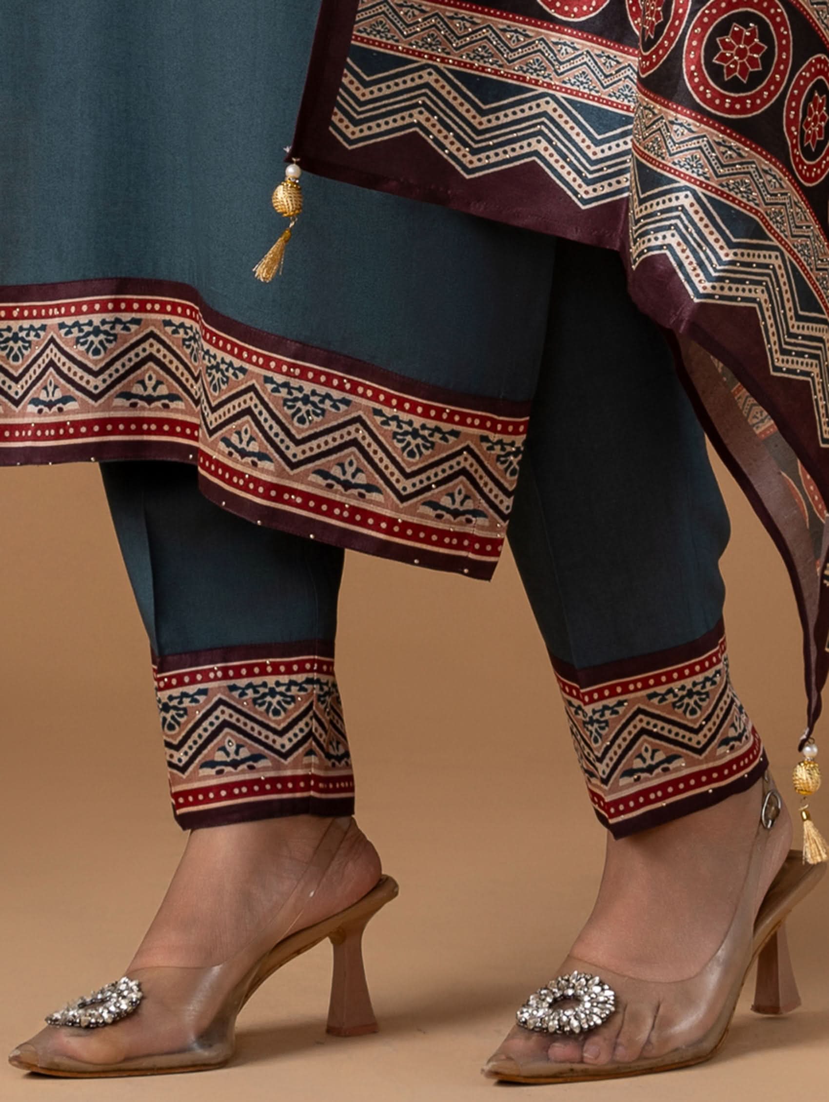Traditional outfit with patterned fabric and pants on a beige background
