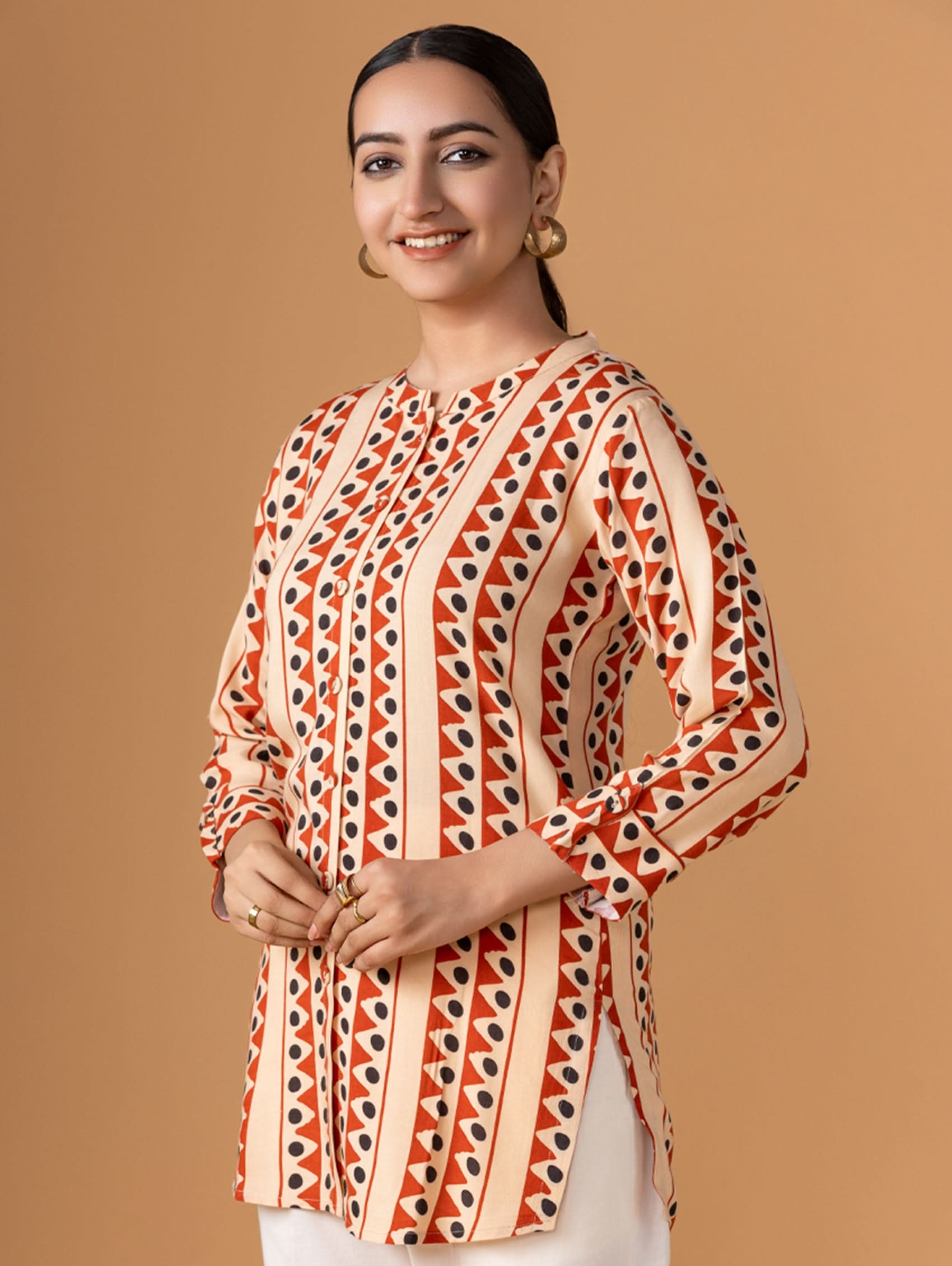 Woman wearing a patterned top against a brown background