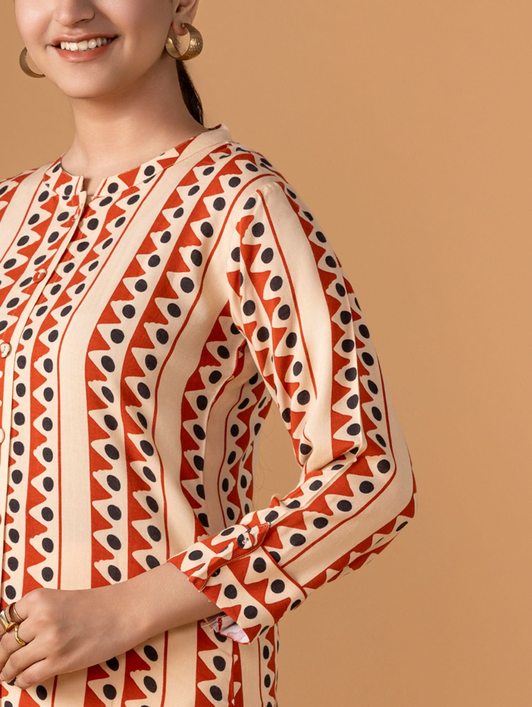 Woman wearing a patterned long-sleeve top on a beige background
