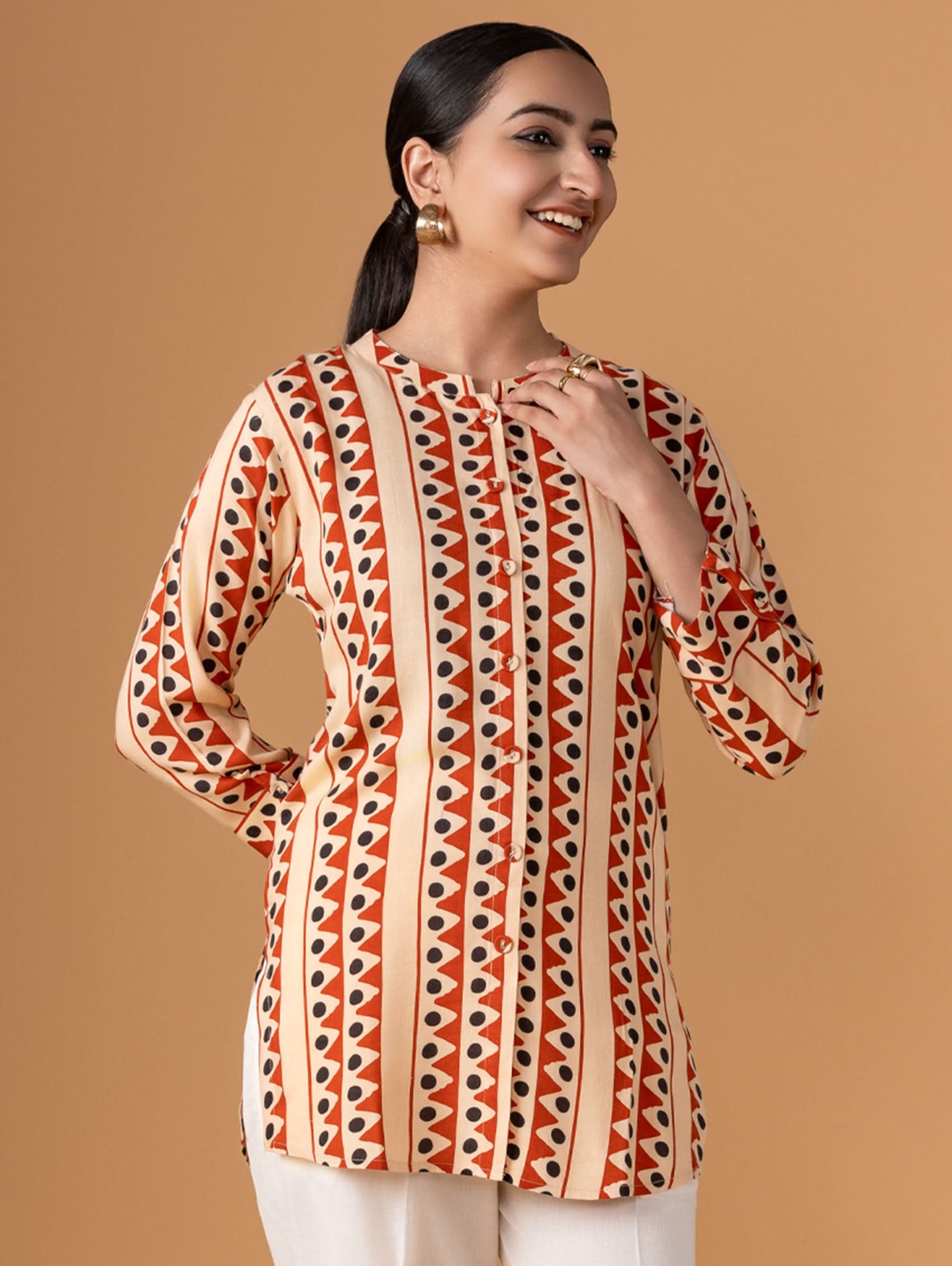 Woman wearing a patterned top with a brown background