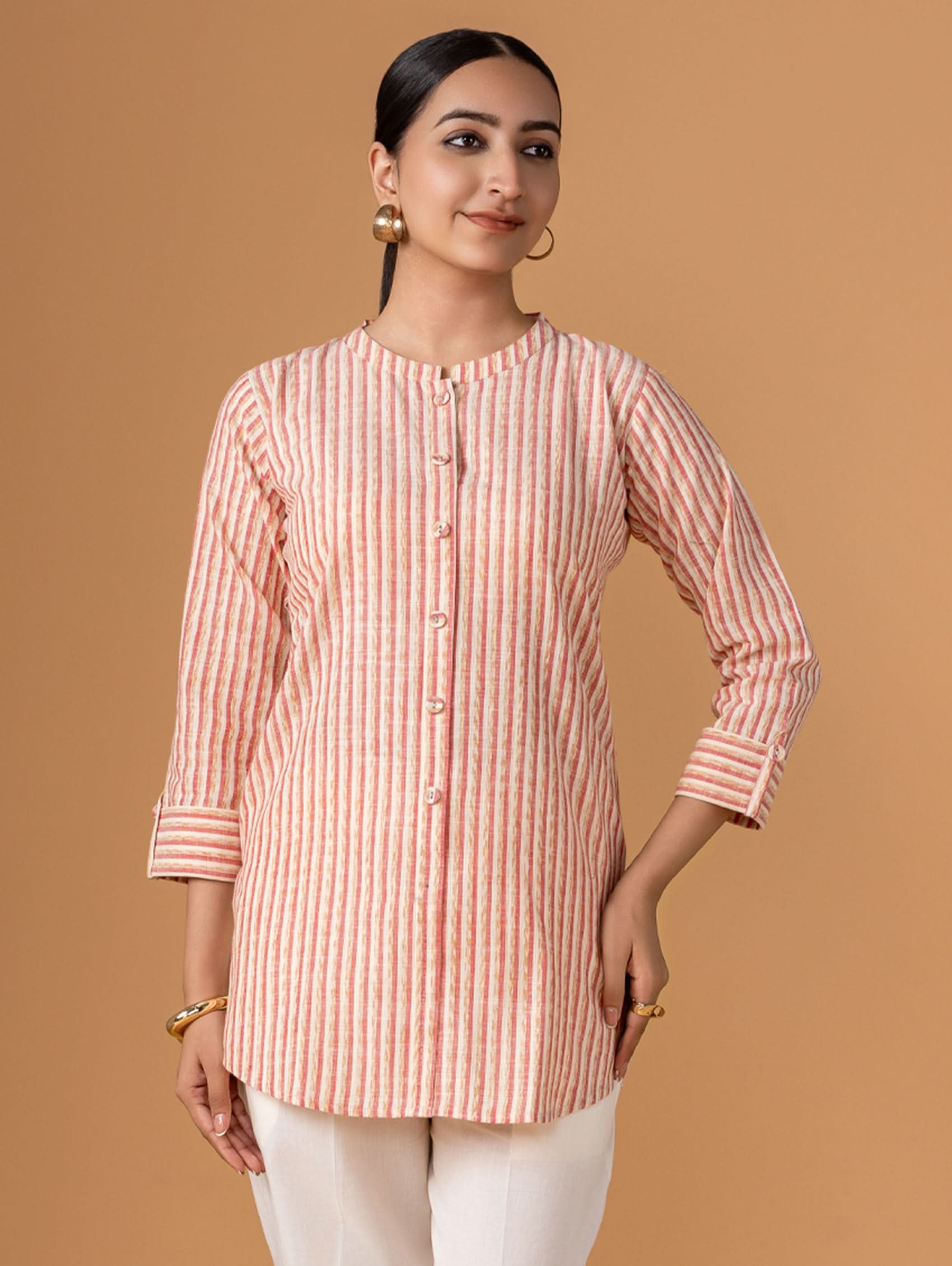 Woman wearing a pink and white striped shirt against a brown background