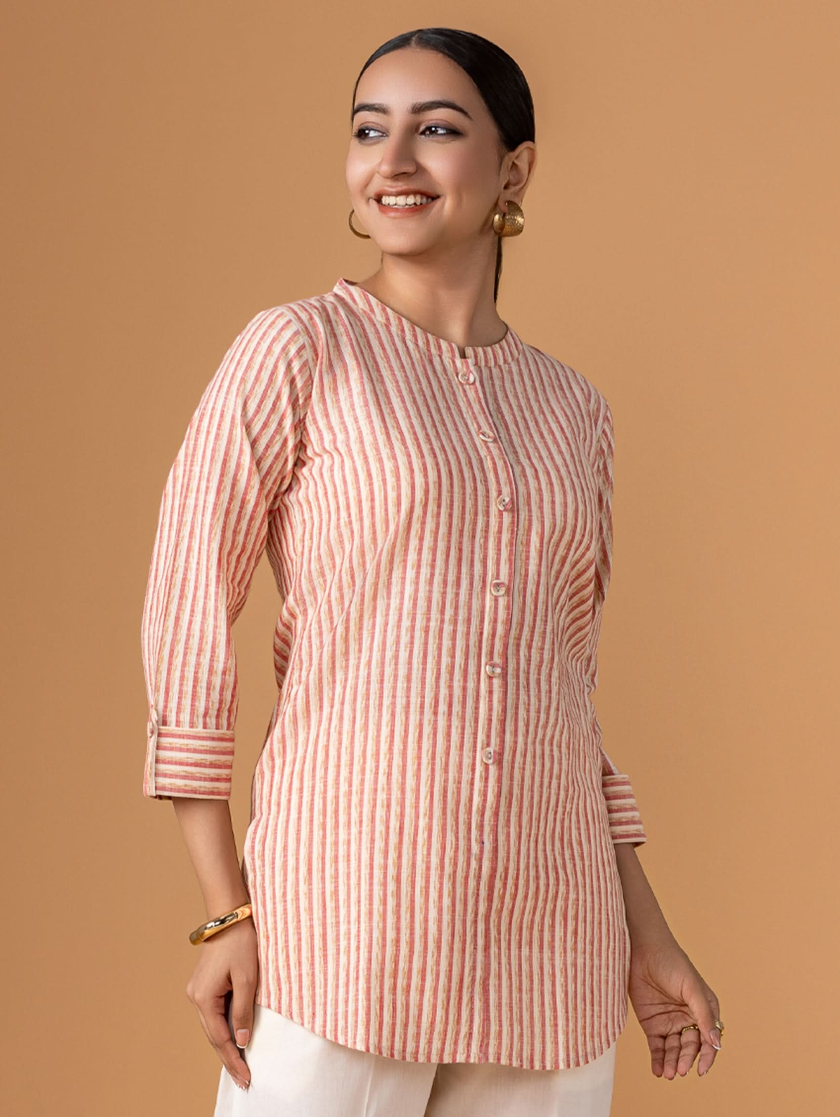Woman wearing a pink and white striped shirt against a brown background