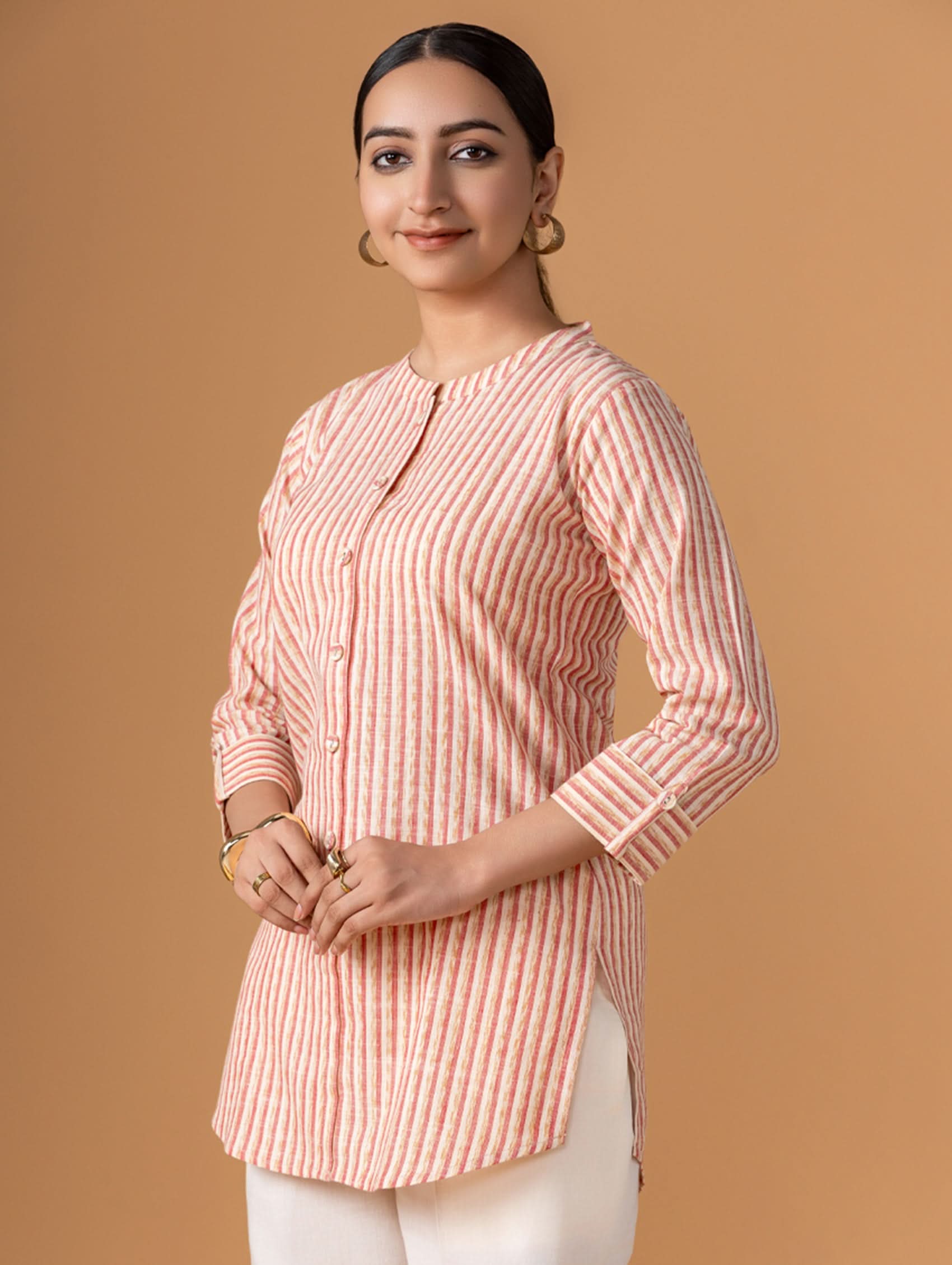 Woman wearing a pink and white striped shirt against a brown background