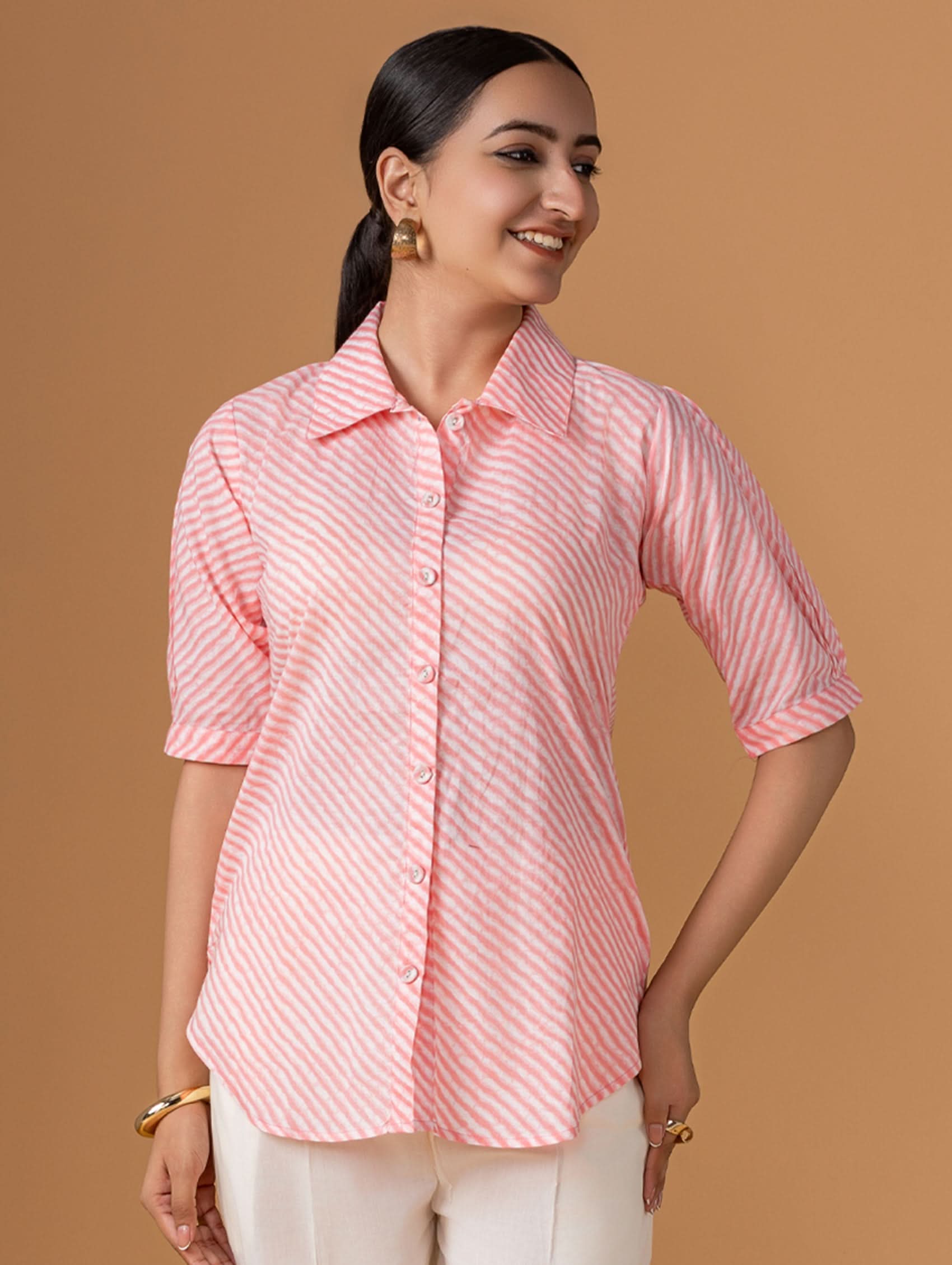 Woman wearing a pink and white striped shirt against a brown background