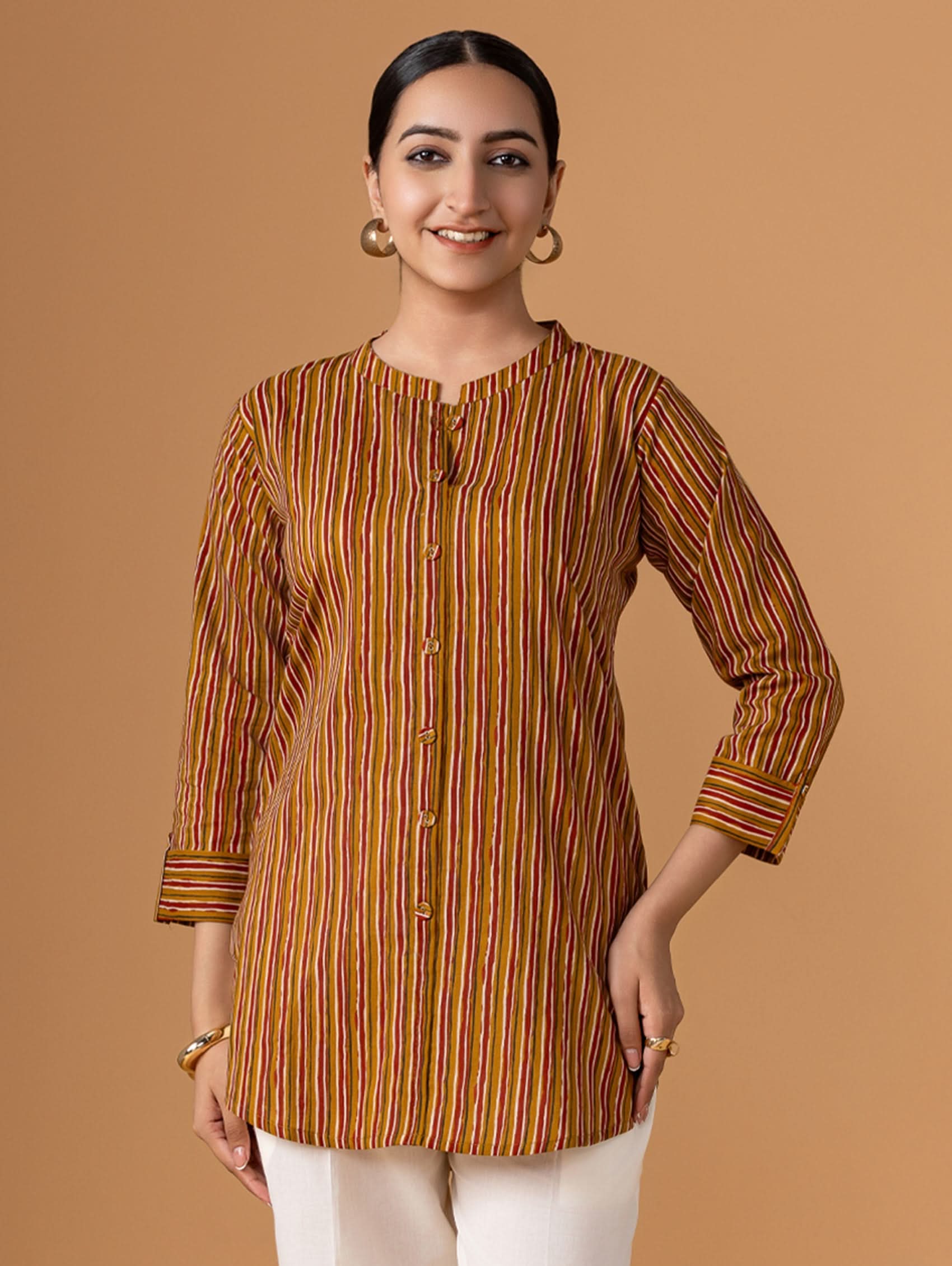 Woman wearing a brown and orange striped shirt against a beige background