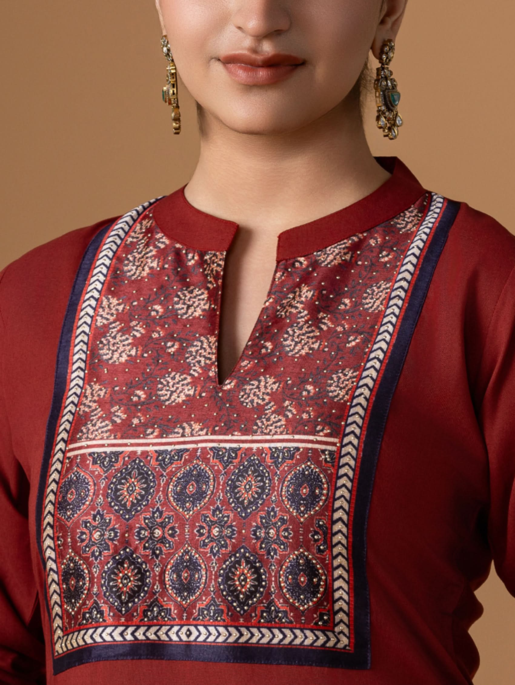 Red traditional outfit with intricate patterns on a beige background
