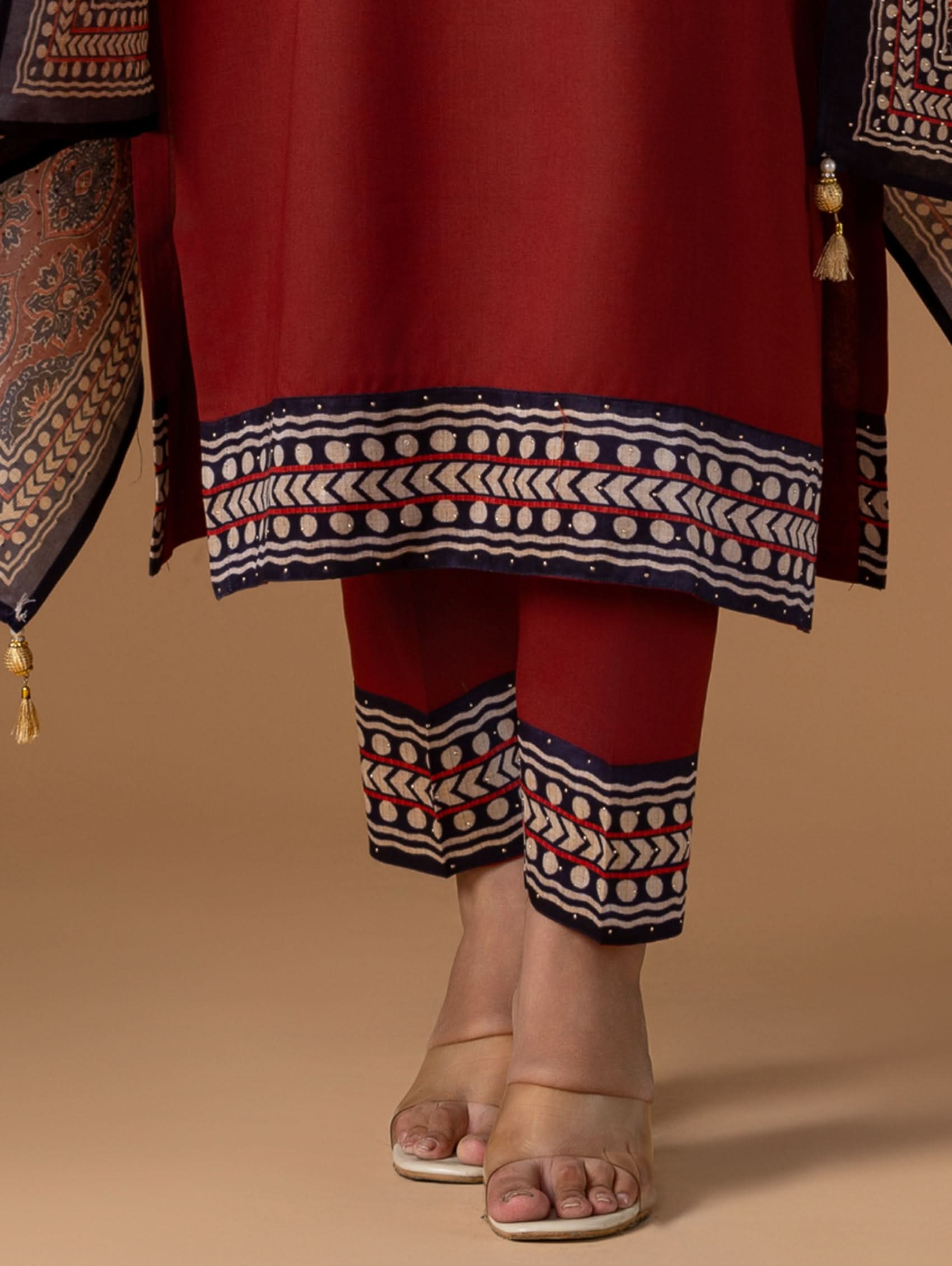 Red traditional outfit with intricate patterns on a beige background