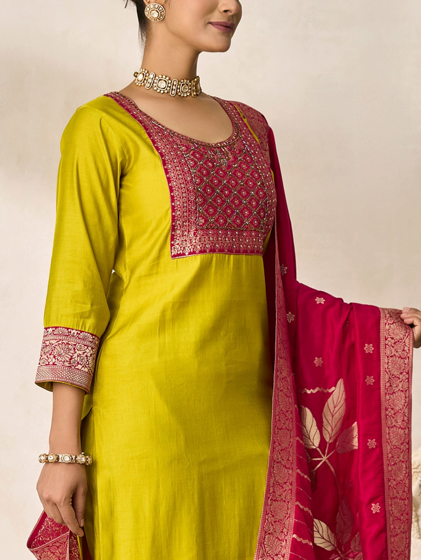 Woman wearing a yellow and red traditional outfit with a matching dupatta.