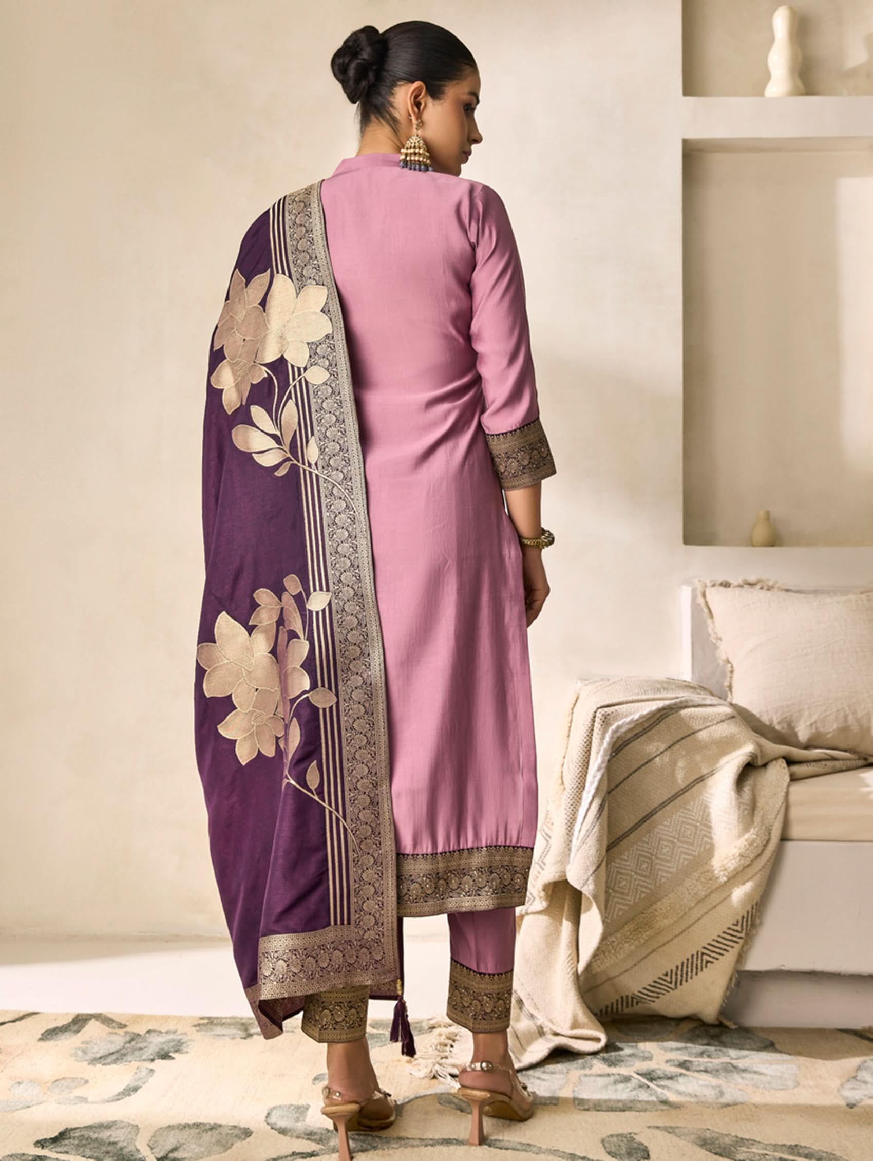 Woman in a pink kurta with a purple floral dupatta in a living room setting