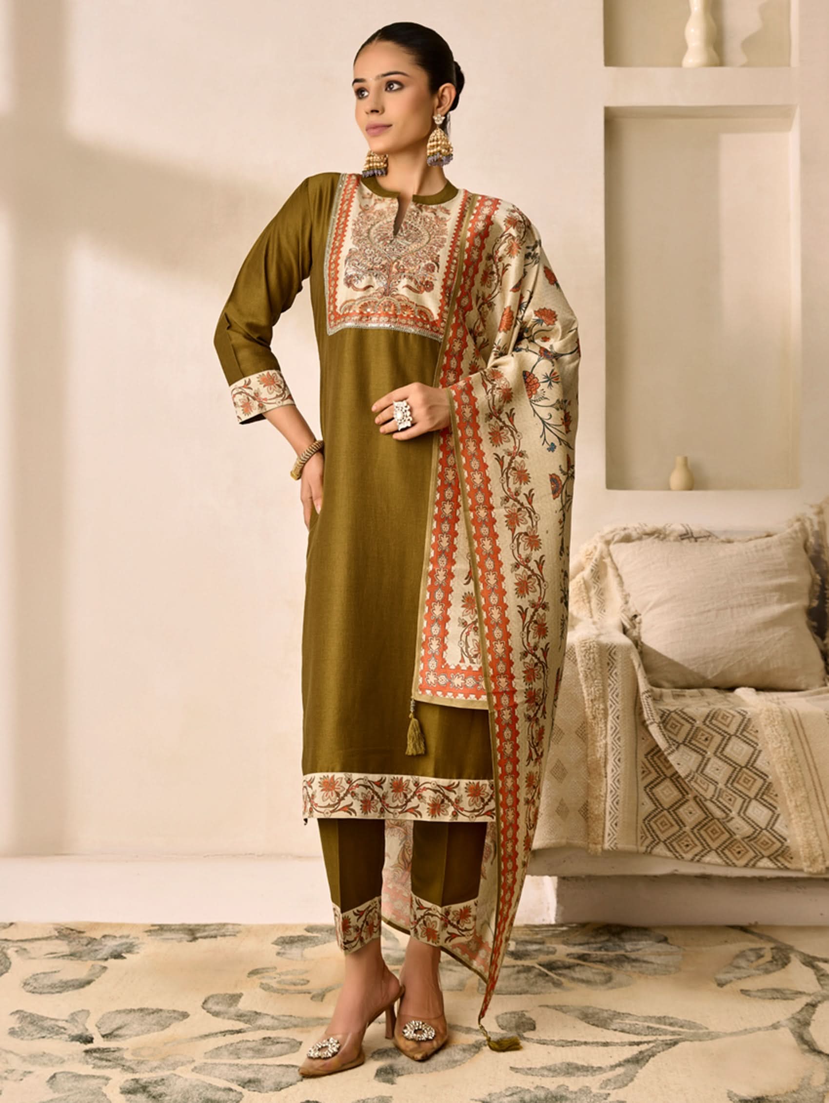Woman wearing a traditional outfit with a floral pattern in a well-lit room.