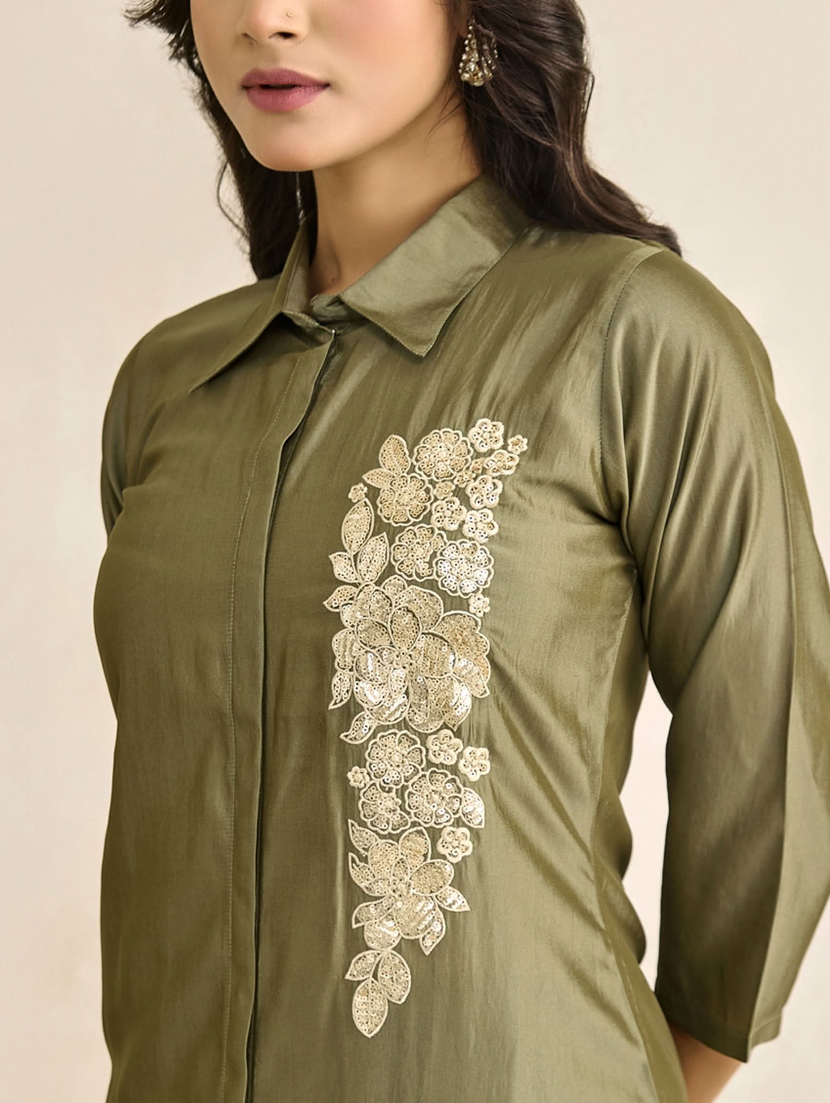 Green shirt with floral embroidery on a beige background