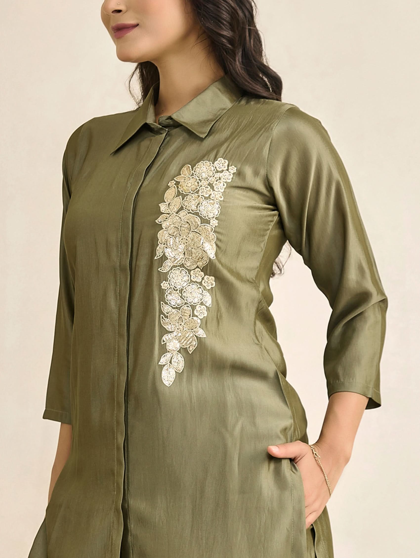 Green shirt with floral embroidery on a beige background