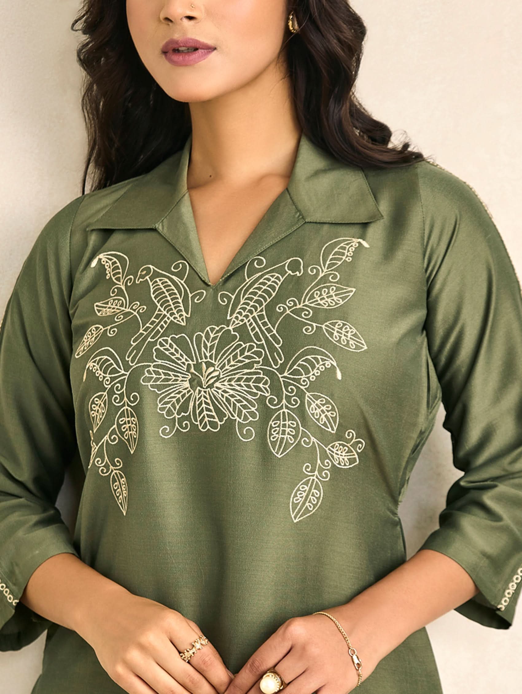 Green V-neck embroidered top with long sleeves, decorative white motifs