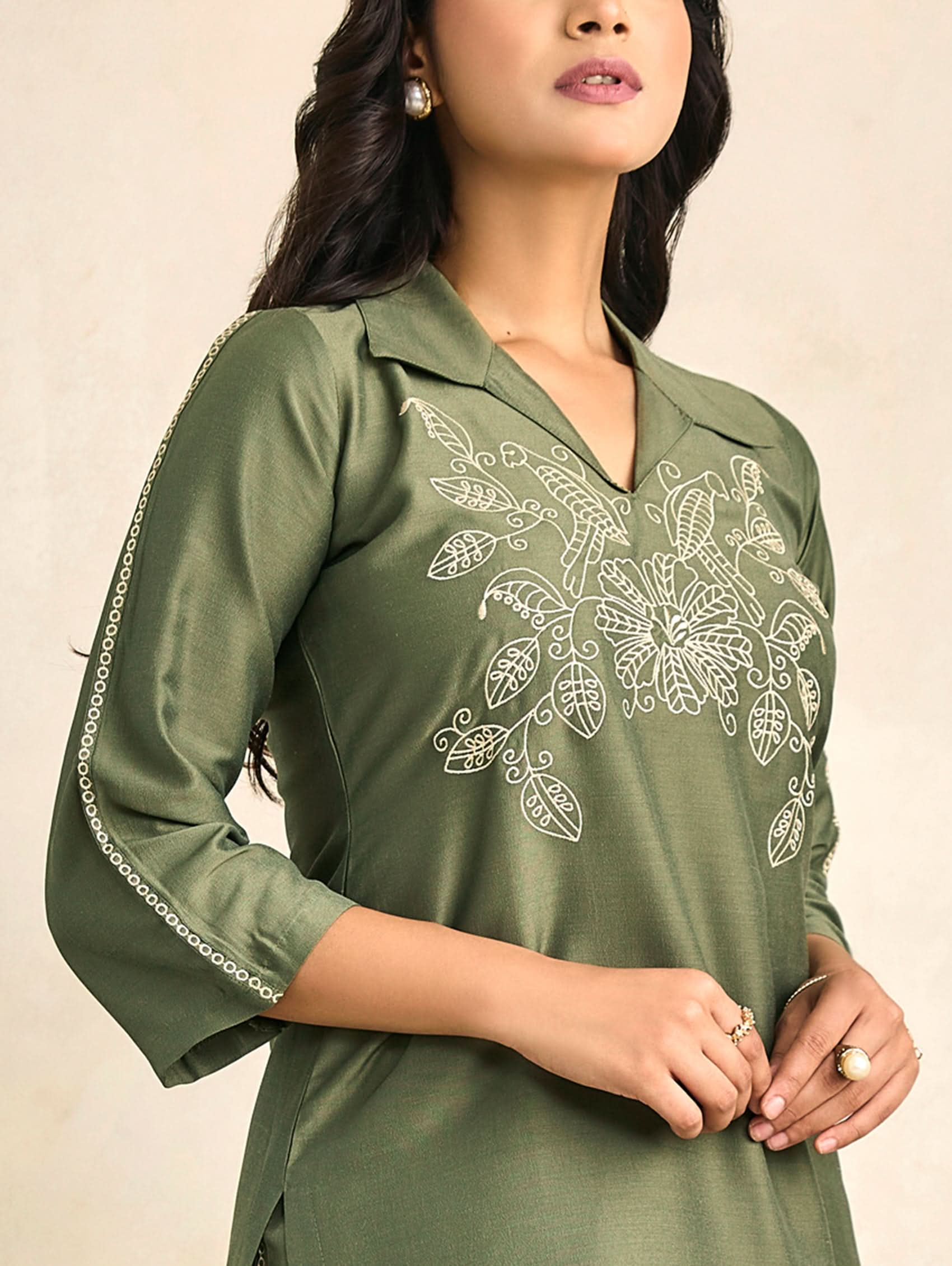 Green embroidered V-neck tunic top with floral motifs on chest