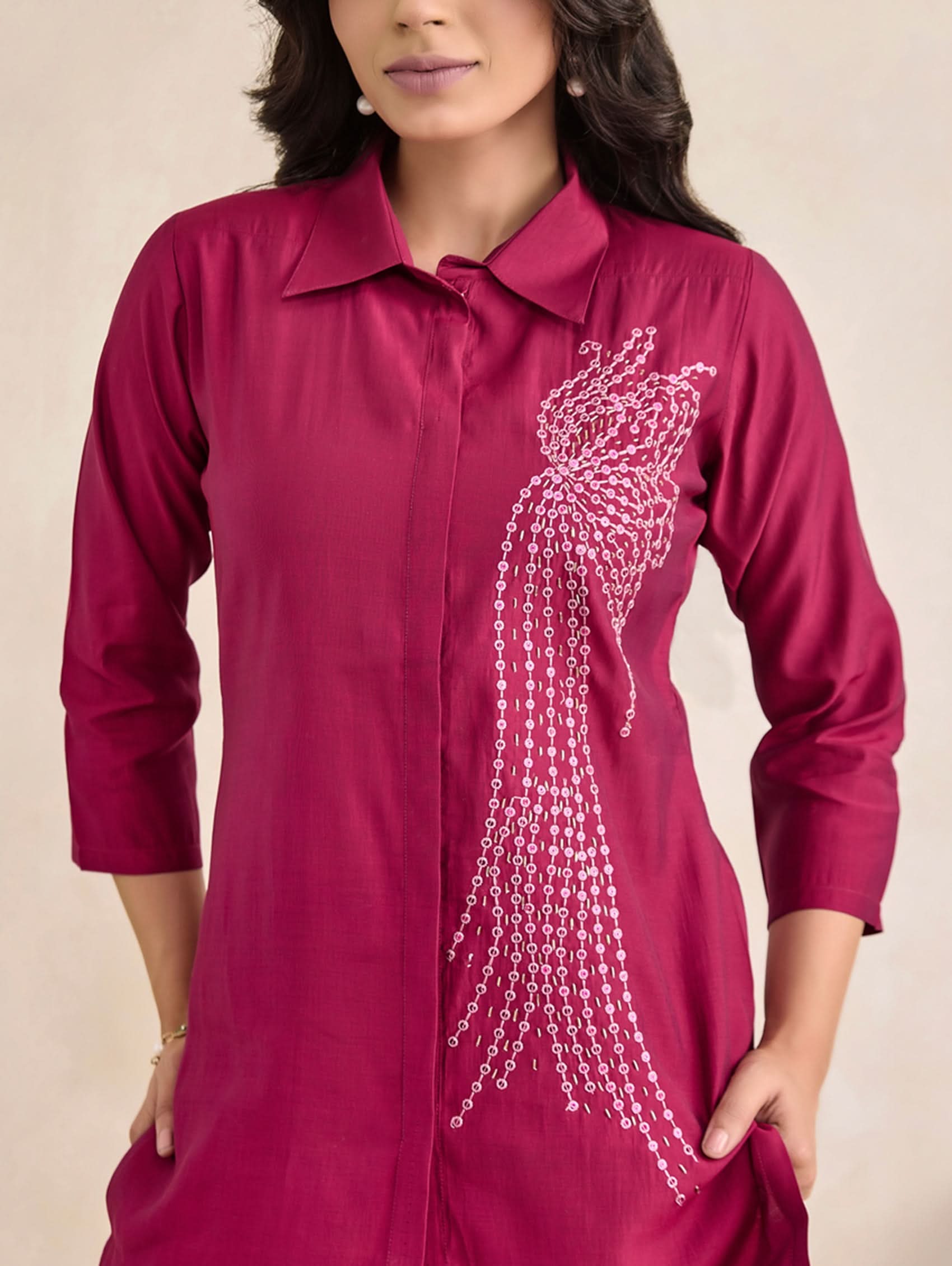 Red shirt with decorative chain design on a beige background
