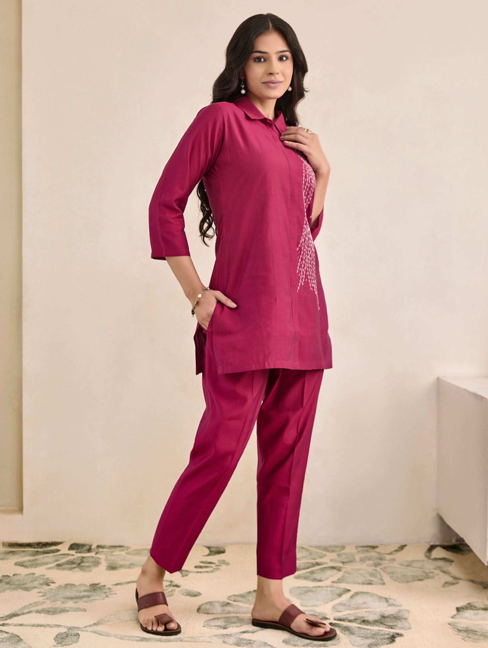 Woman wearing a pink traditional outfit with a plain background