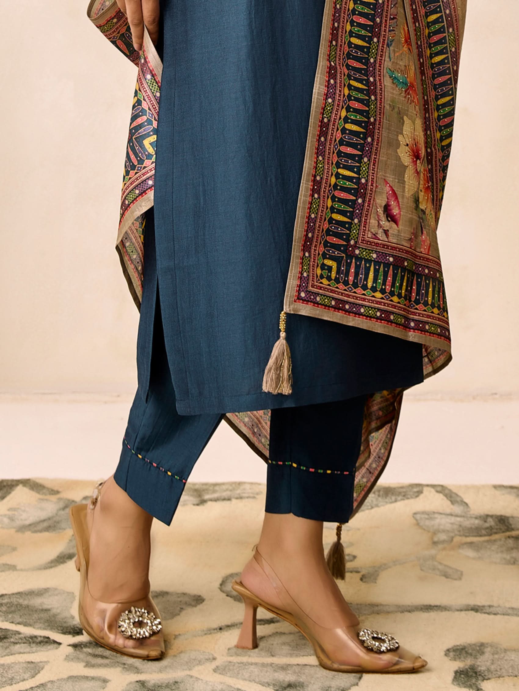 Navy blue traditional outfit with embroidered dupatta on a patterned floor.