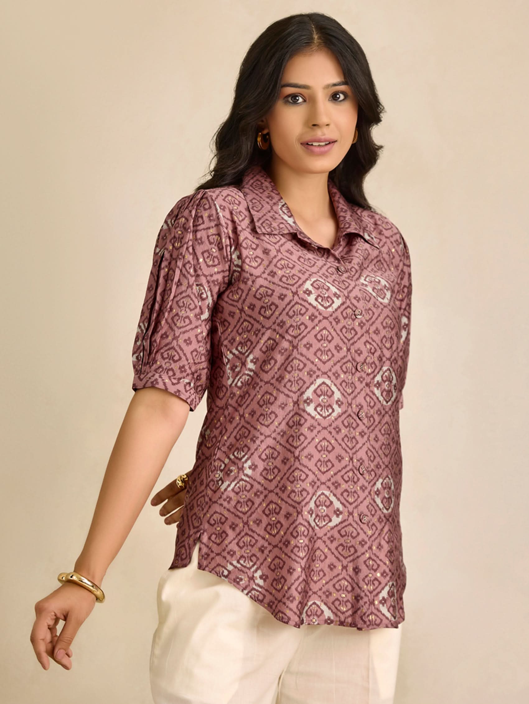 Woman wearing a patterned shirt against a beige background