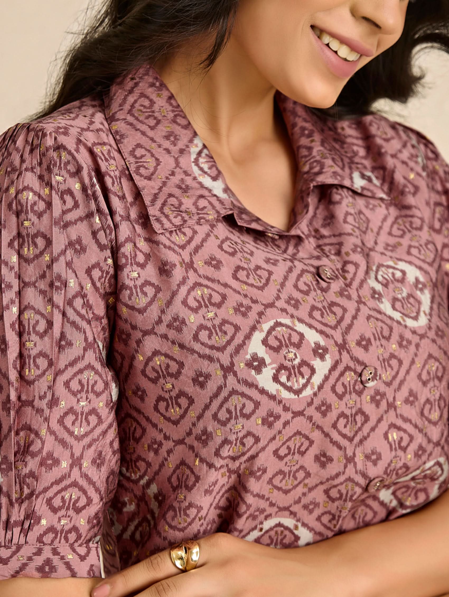 Close-up of a person wearing a patterned shirt with a neutral background