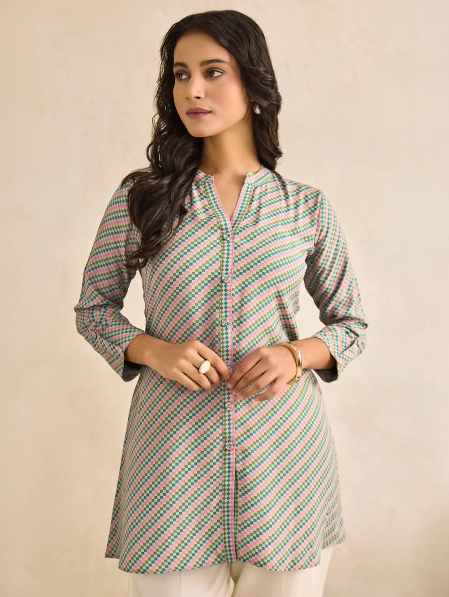 Woman wearing a patterned shirt against a beige background