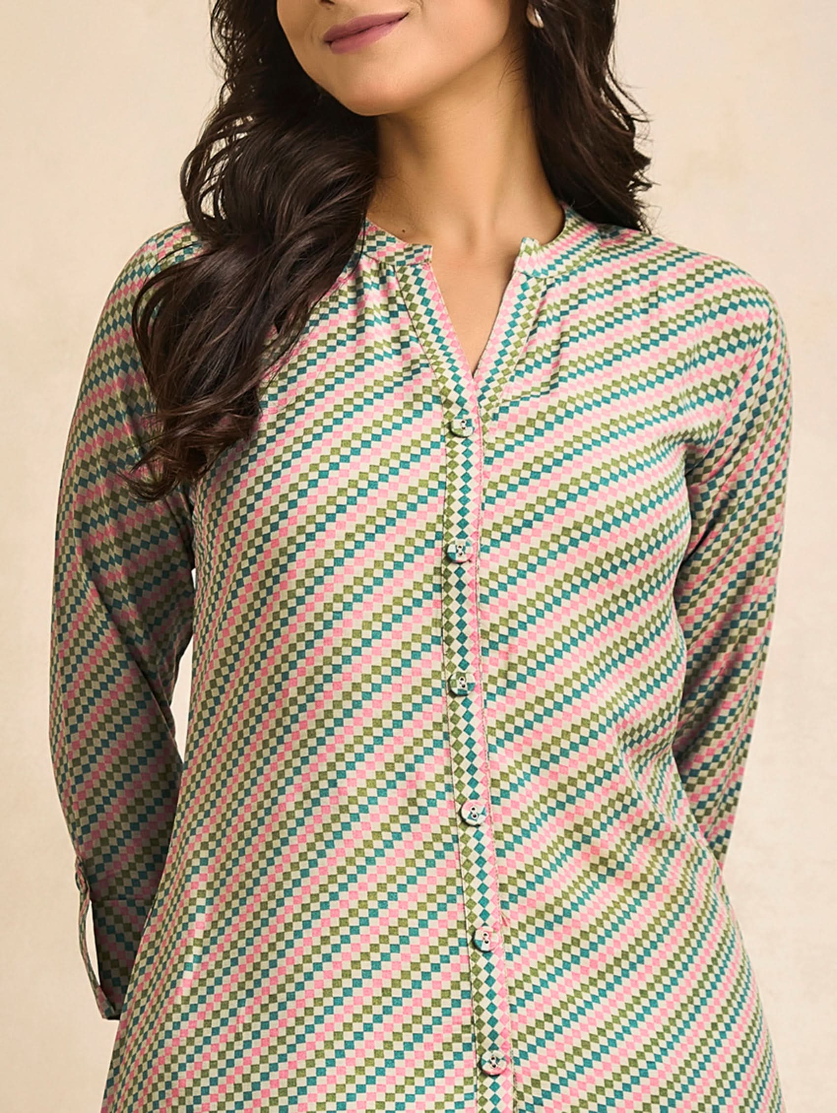 Woman wearing a patterned shirt with a beige background