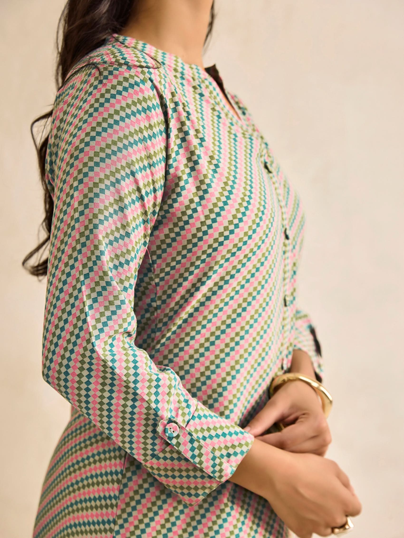 Person wearing a colorful striped shirt with a neutral background