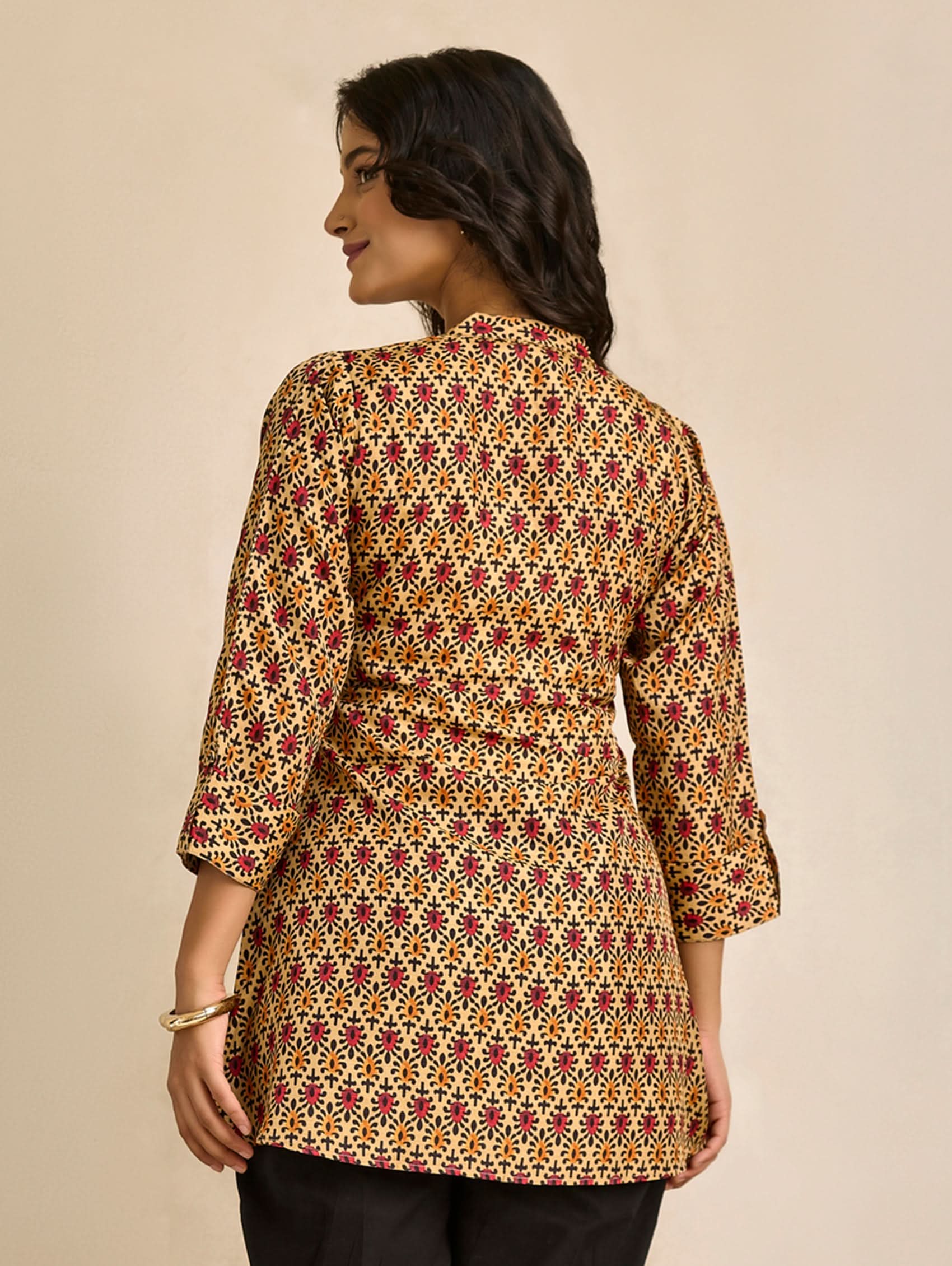 Woman wearing a patterned jacket on a beige background